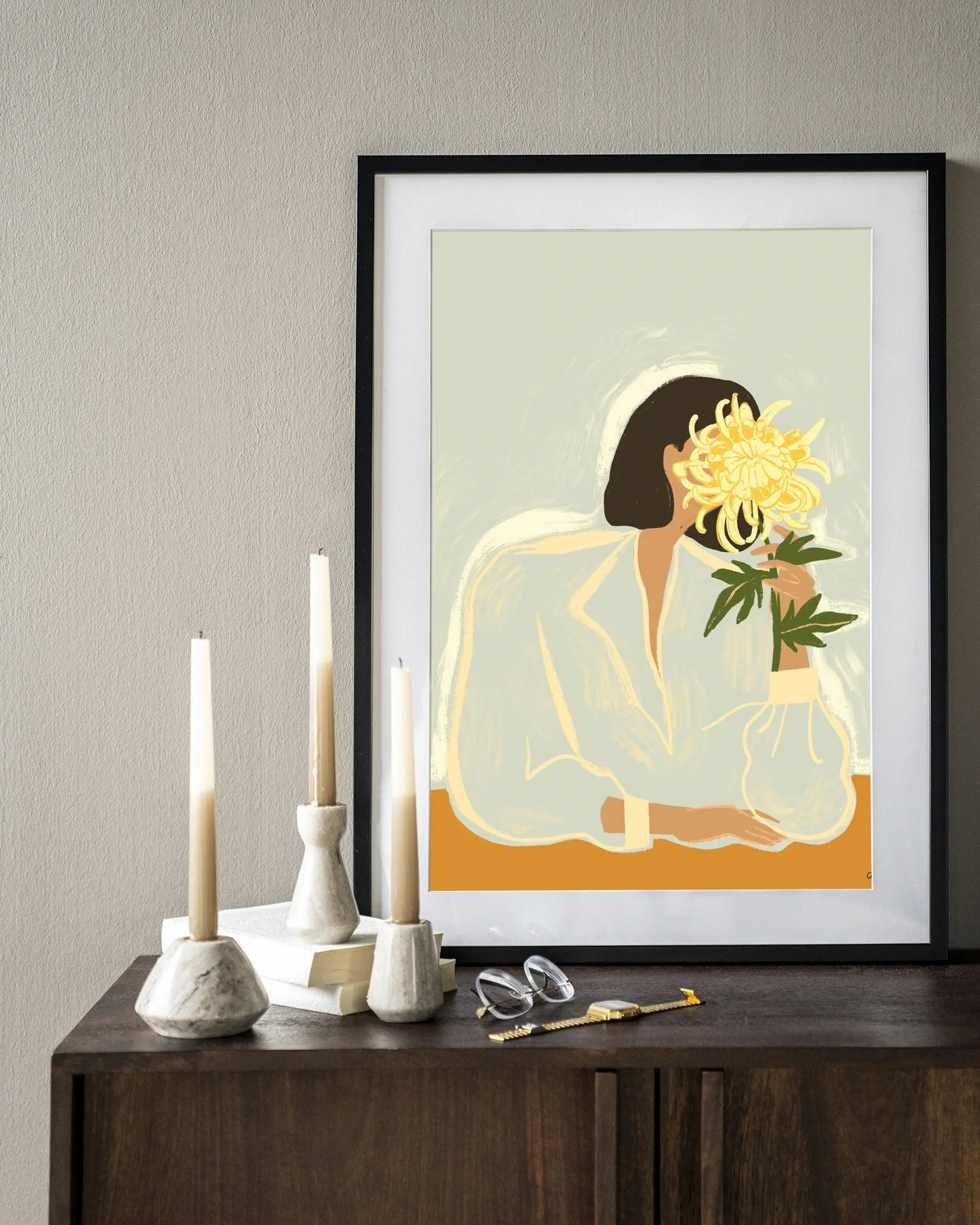 Wandkleed The Chrysante Mum hangt boven een houten dressoir met kaarsen en boeken - Urban Cotton