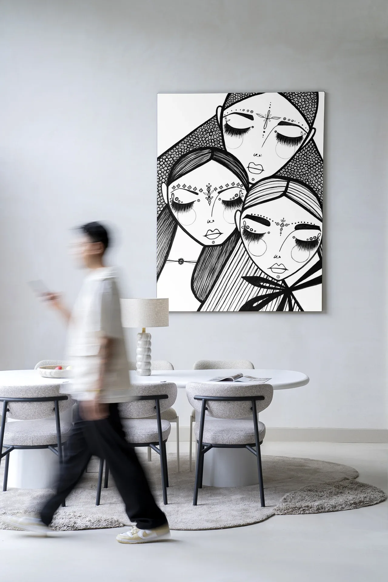 Wandkleed Close van Urban Cotton met een illustratie van drie vrouwen, hangend boven een eettafel