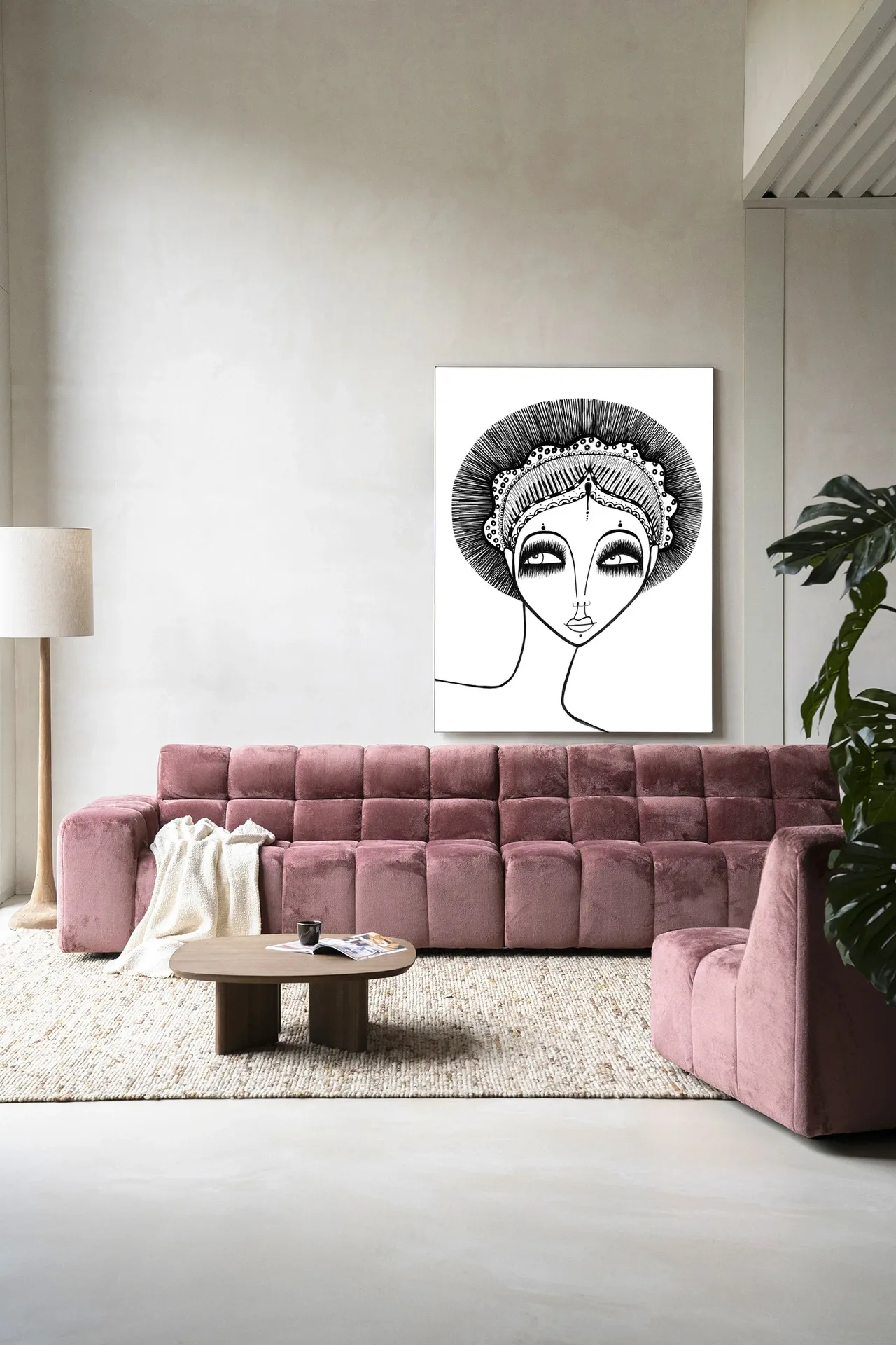 Wandkleed Leyla - Urban Cotton hangend boven een roze bank in een moderne woonkamer