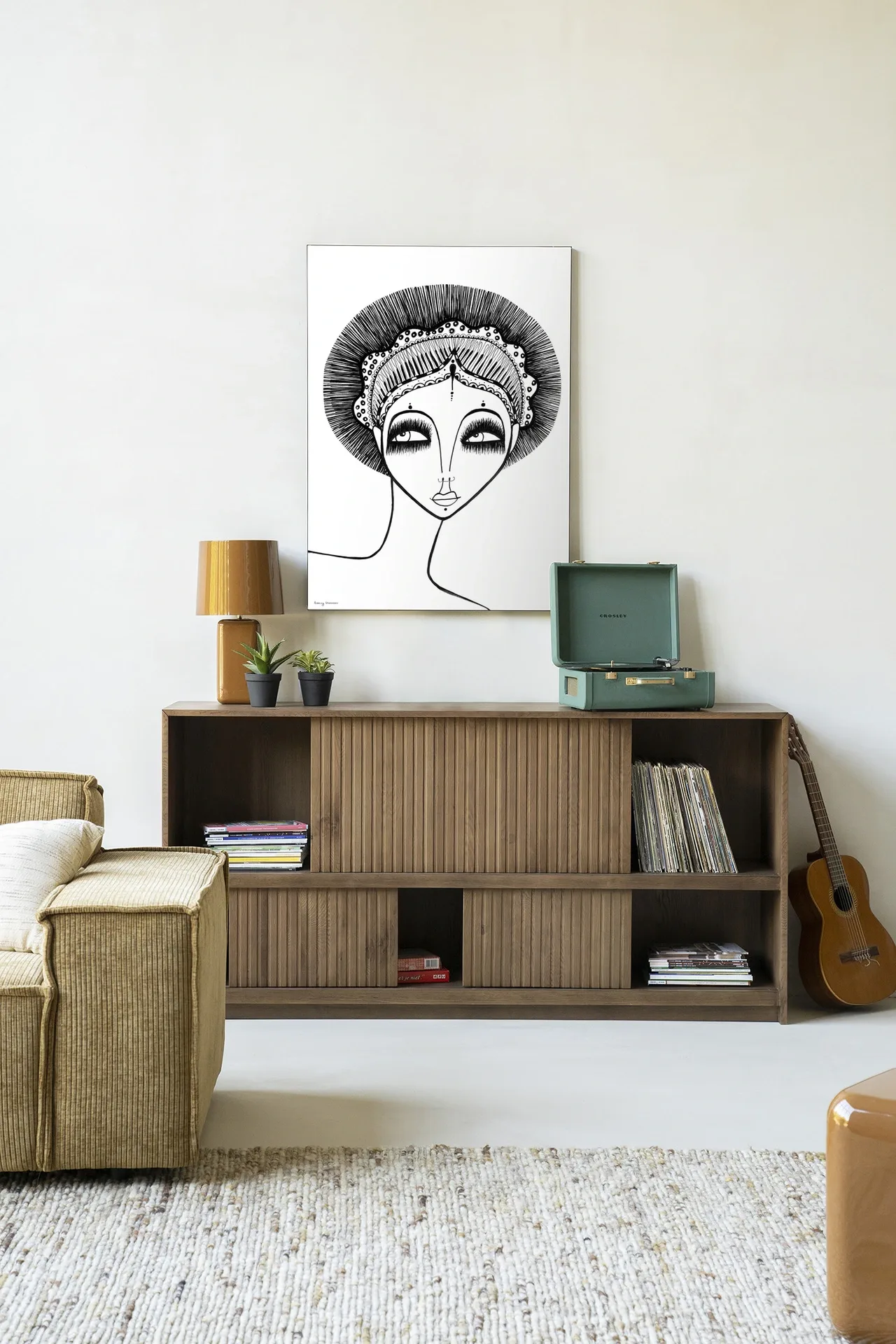 Wandkleed Leyla - Urban Cotton hangt boven een houten dressoir in een lichte woonkamer