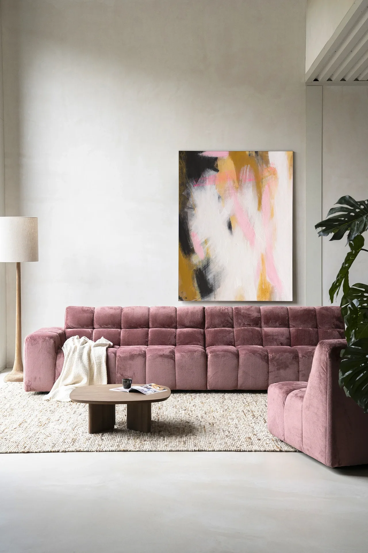 Abstract Moods wandkleed van Urban Cotton hangt boven een roze bank in een moderne woonkamer