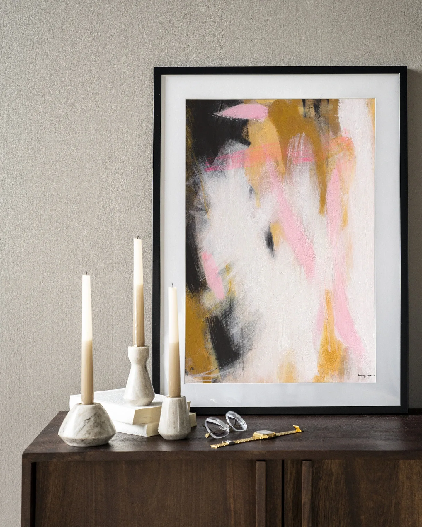 Wandkleed Abstract Moods - Urban Cotton hangt boven een houten dressoir met kaarsen en accessoires