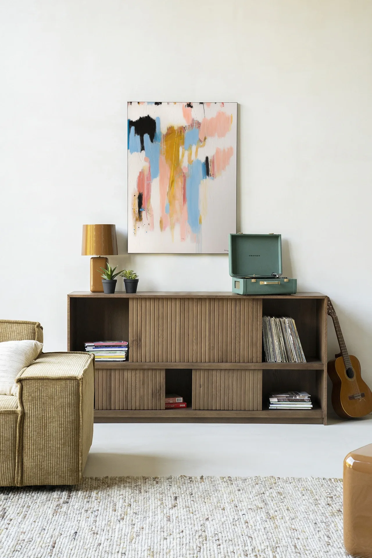 Wandkleed Better Days - Urban Cotton hangt boven een houten dressoir in een lichte woonkamer