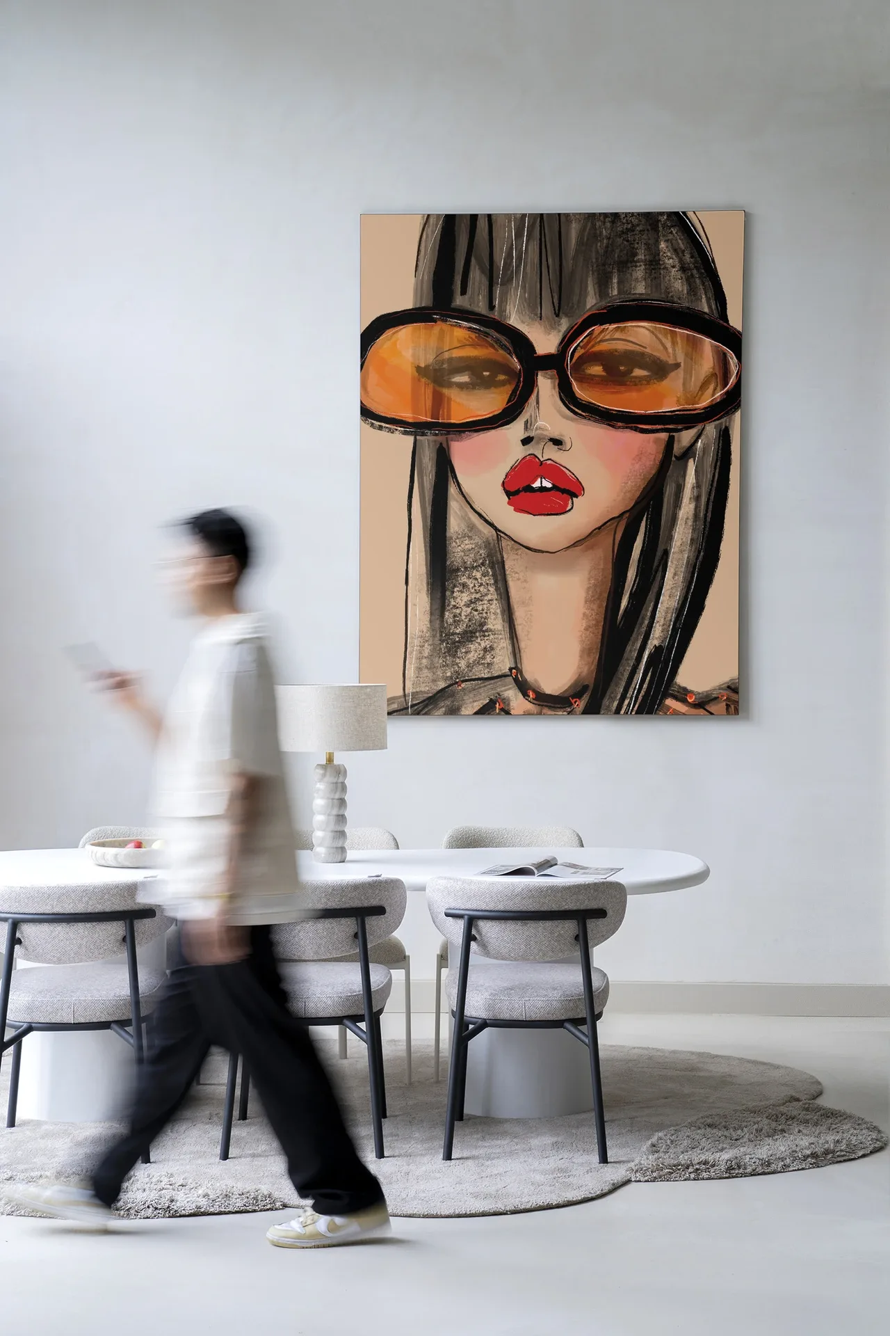 Wandkleed Sunny Orange - Urban Cotton hangt aan een witte muur in een modern interieur met persoon die voorbijloopt