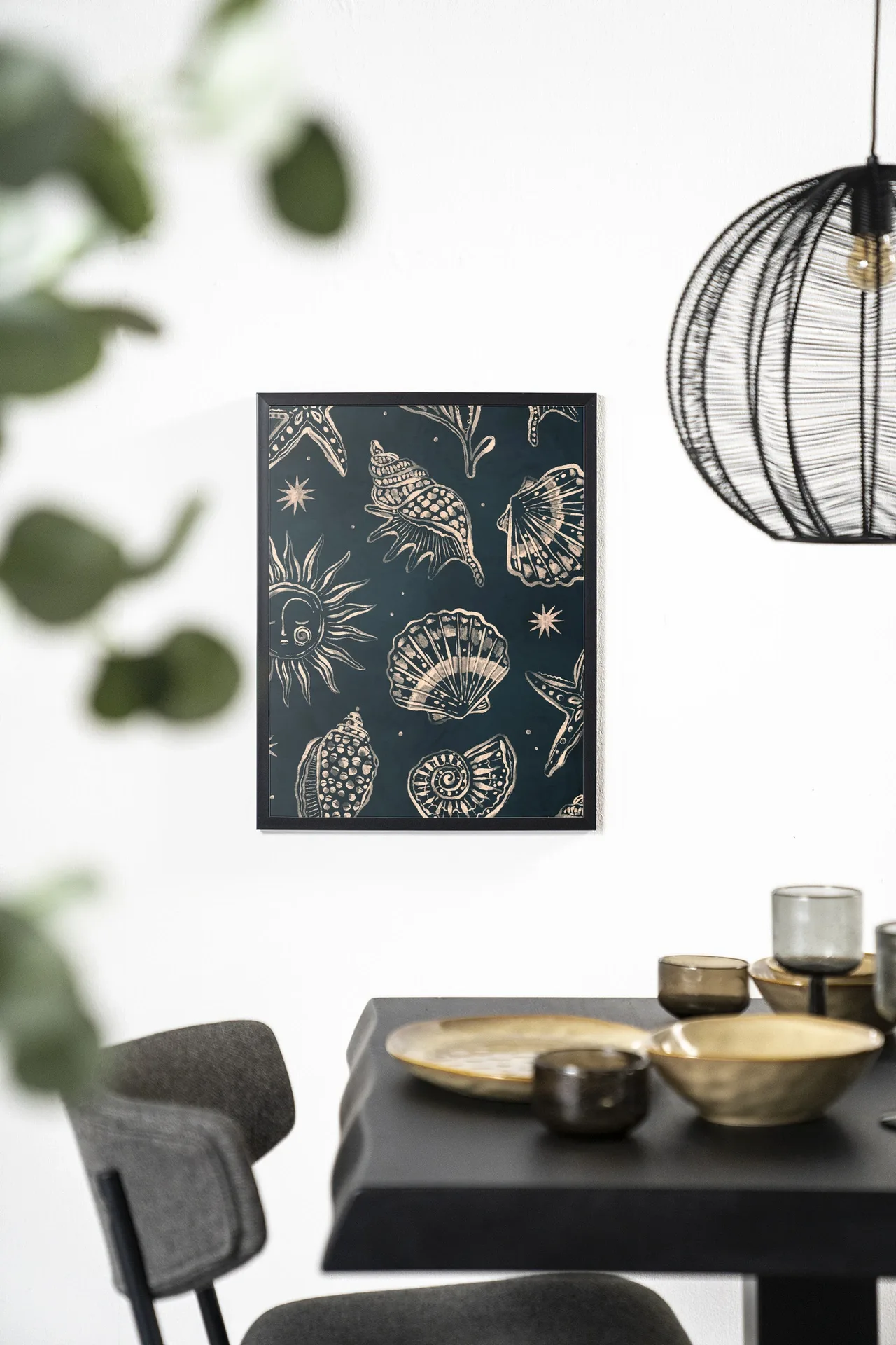 Wandkleed Seashells Midnight - Urban Cotton hangend aan een witte muur boven een zwarte eettafel