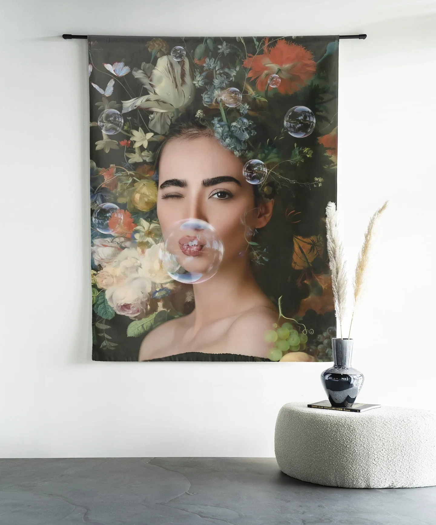 Wandkleed Gifts Of Nature - Urban Cotton hangend aan een zwarte roede boven een poef met een vaas