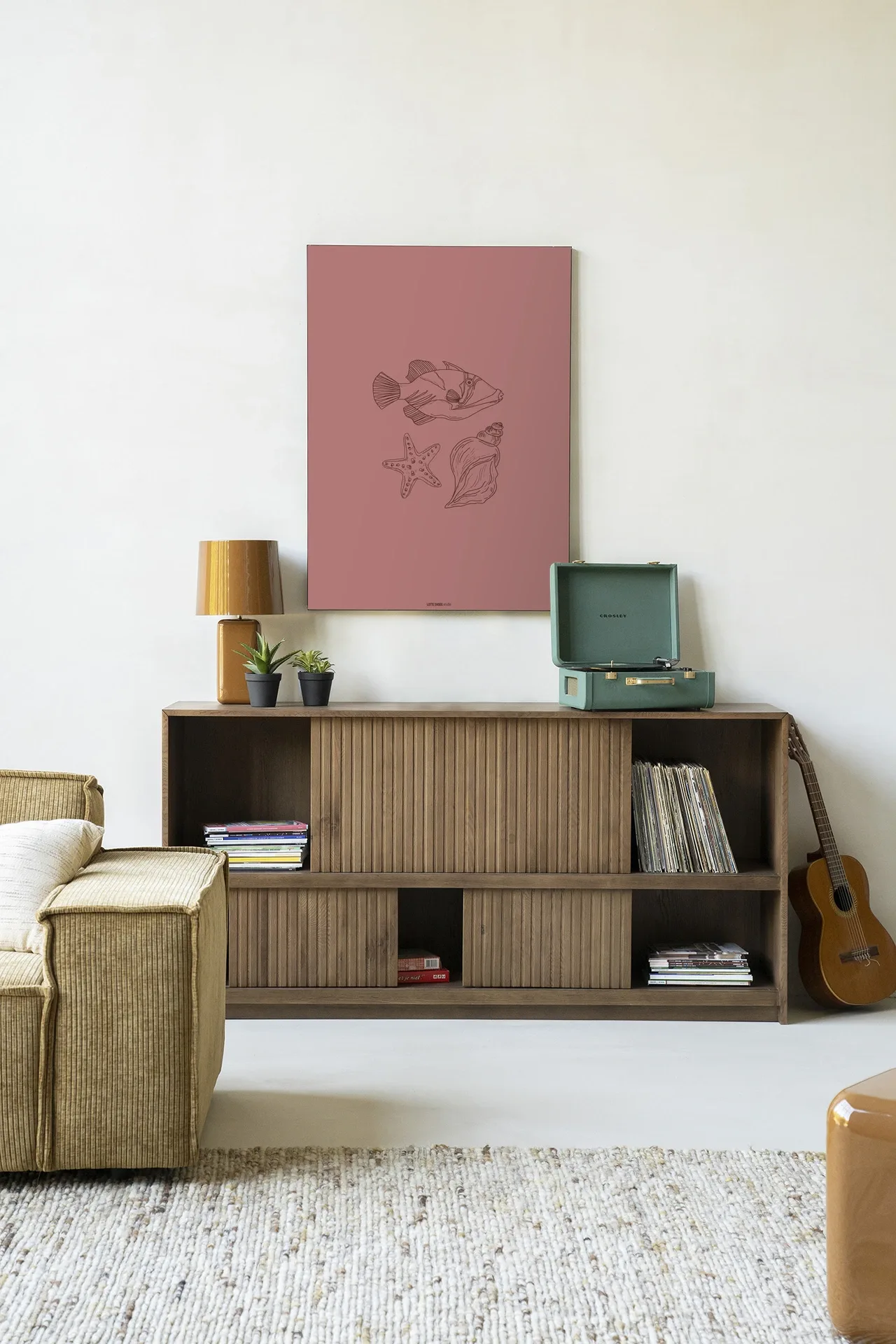Wandkleed Tres Pisces - Urban Cotton hangend boven een houten dressoir in een lichte woonkamer