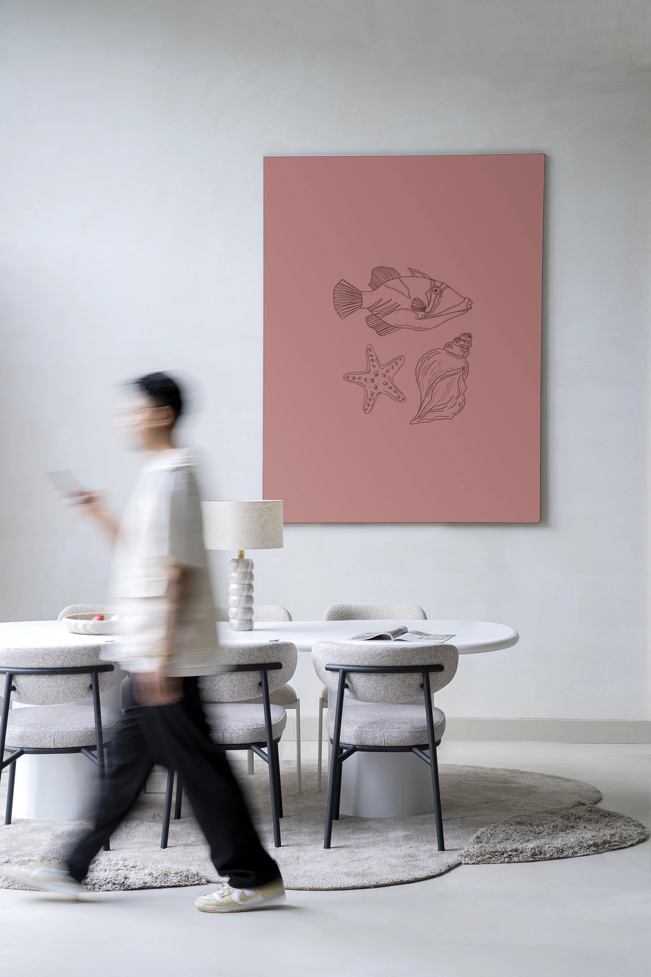 Wandkleed Tres Pisces - Urban Cotton hangend aan een witte muur boven een eettafel