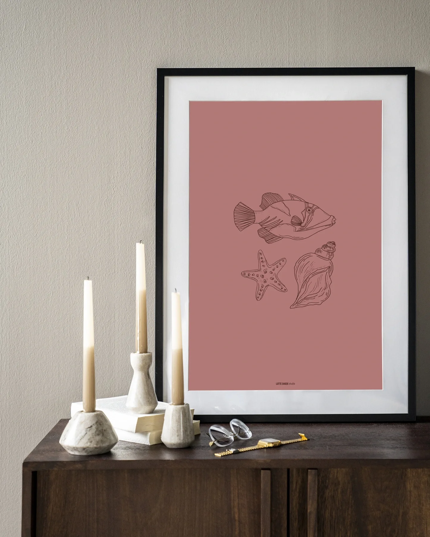 Wandkleed Tres Pisces - Urban Cotton hangt aan een muur boven een houten dressoir met kaarsen