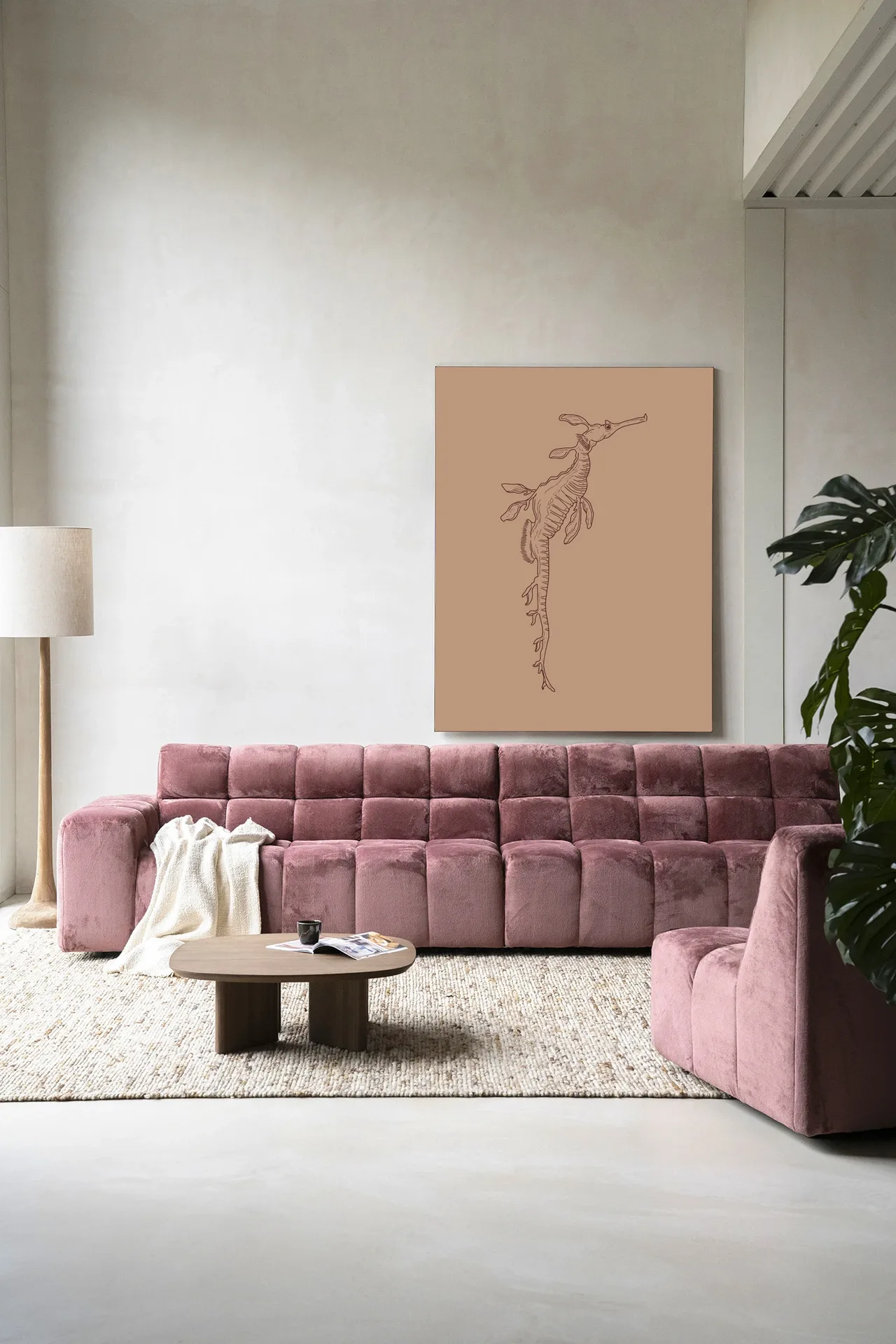 Ein rosa Sofa und Sessel vor einer Wand mit dem Wandteppich Lau Lau - Urban Cotton