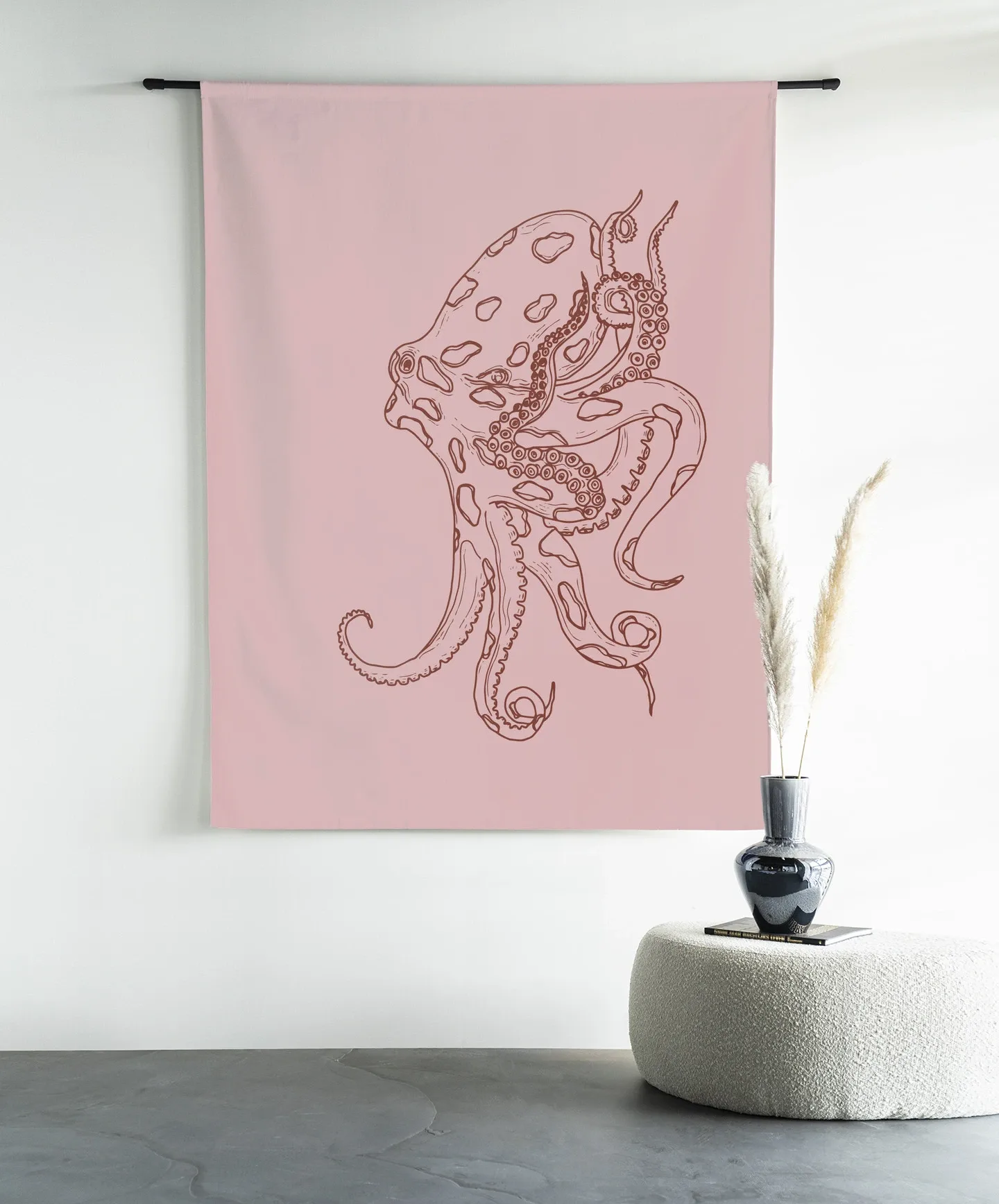Wandkleed Polypus - Urban Cotton hangend aan een zwarte roede in een moderne kamer met een poef en vaas