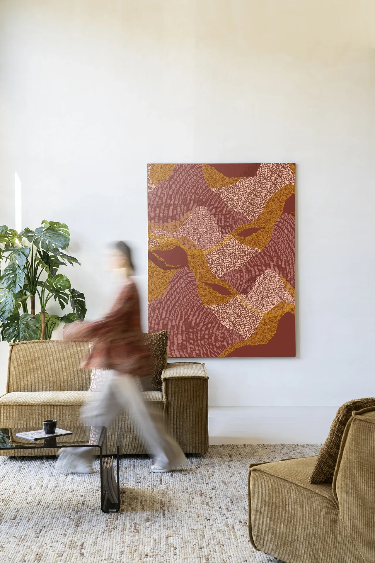 Wandkleed La Ondas - Urban Cotton hangt in een lichte woonkamer met een persoon in beweging
