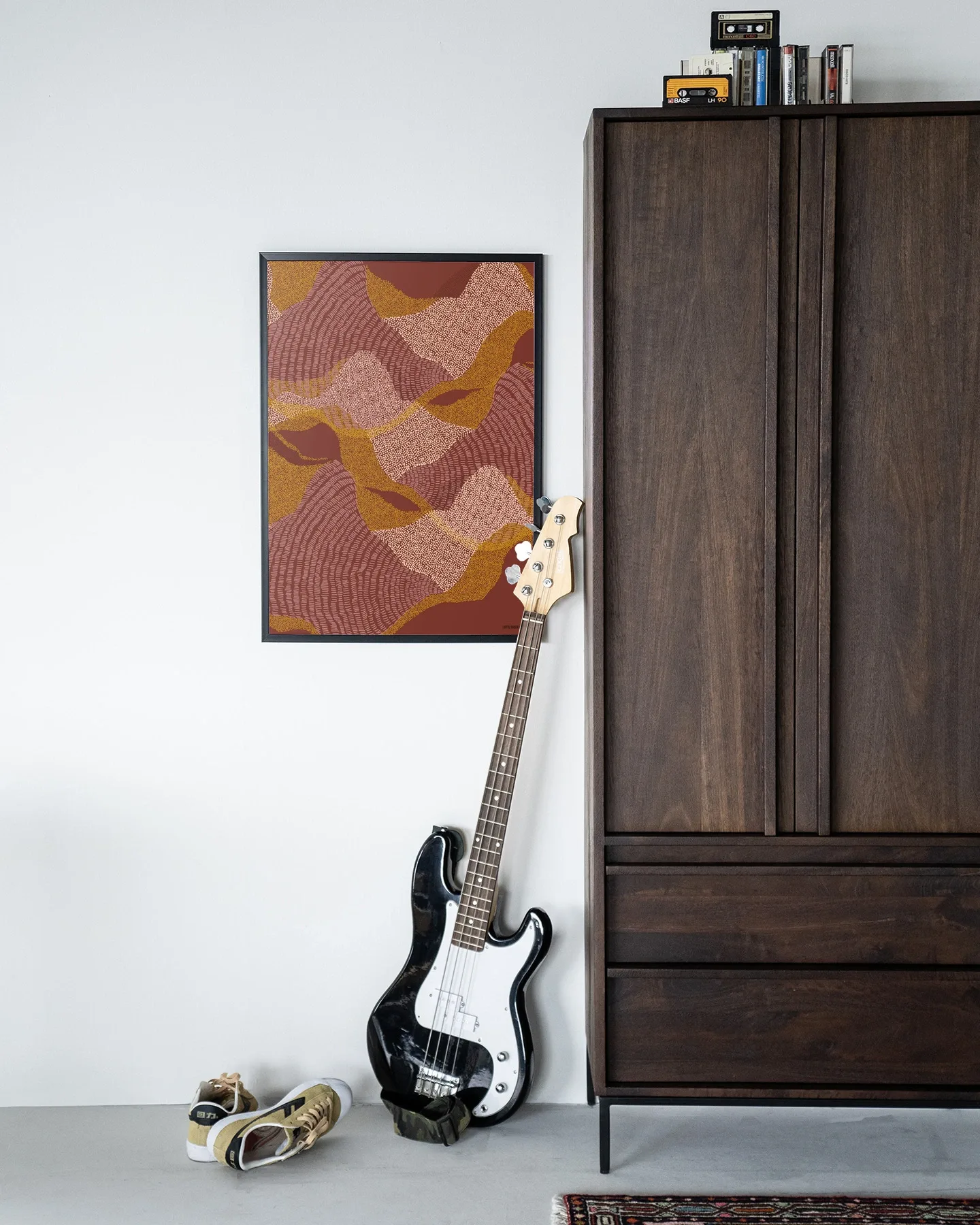 Wandkleed La Ondas - Urban Cotton hangt aan een witte muur naast een donkerbruine kast