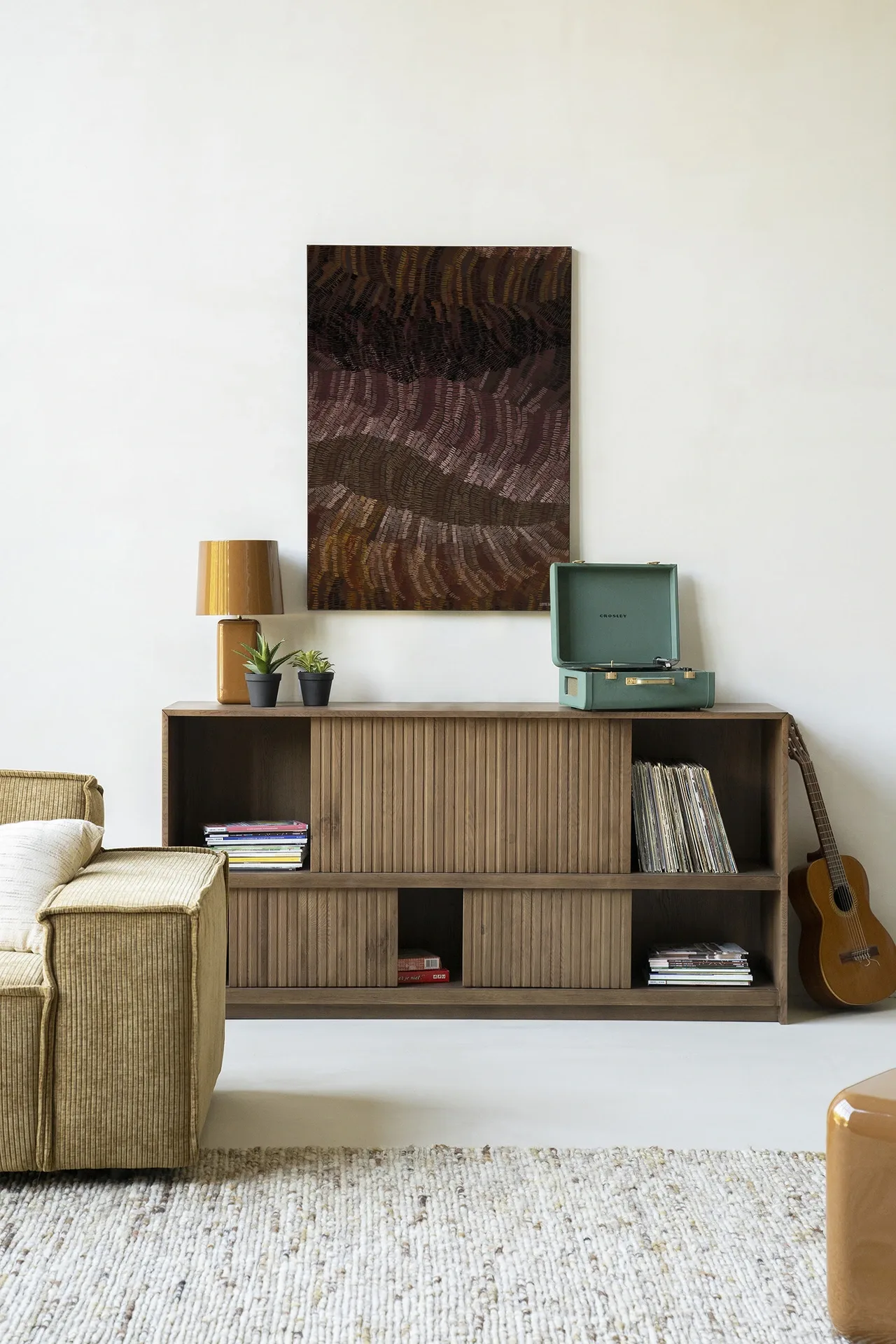 Wandkleed Olanan - Urban Cotton hangend boven een houten dressoir in een lichte woonkamer