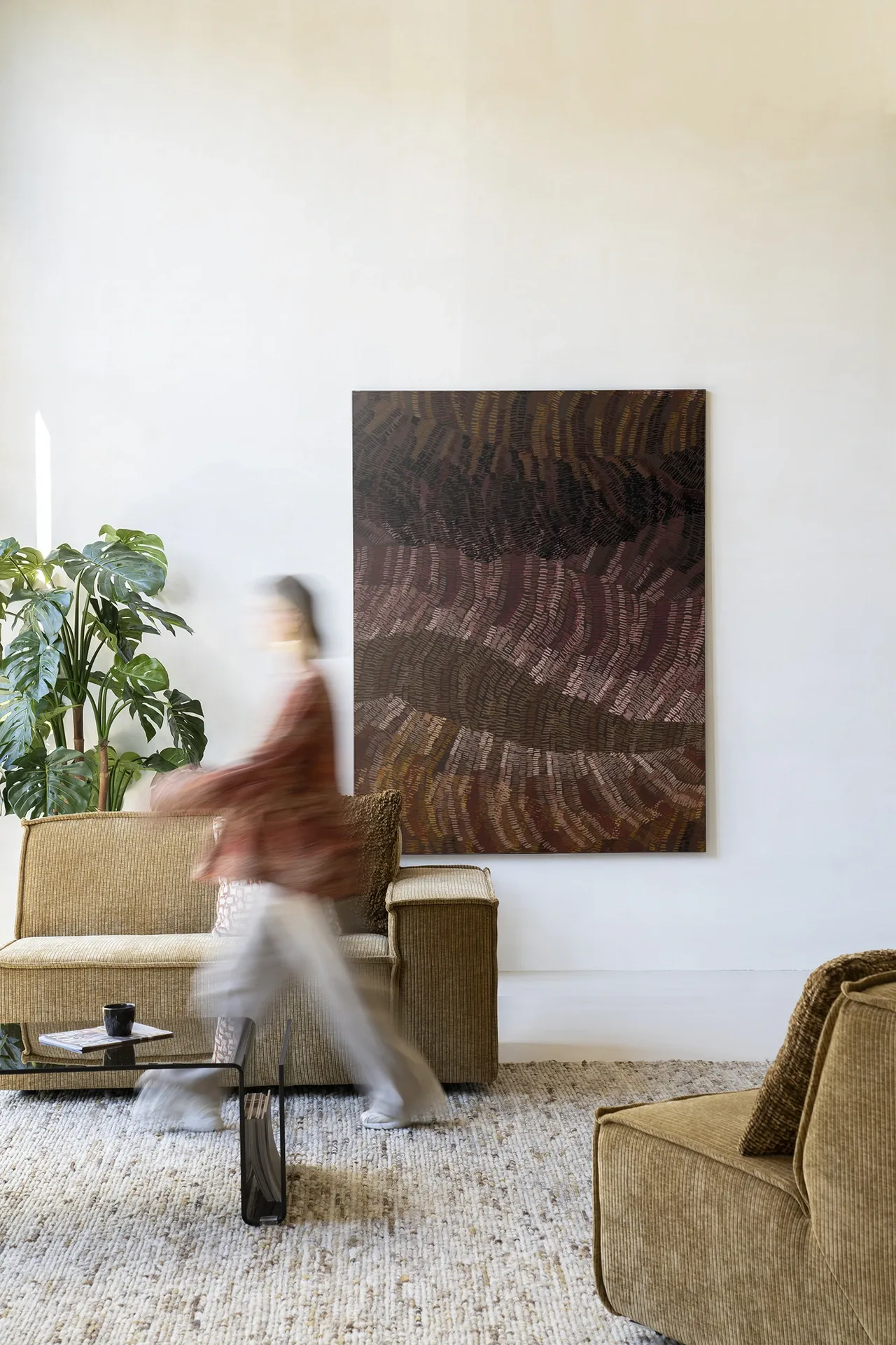Wandkleed Olanan in een moderne woonkamer met een persoon die voorbij loopt - Urban Cotton