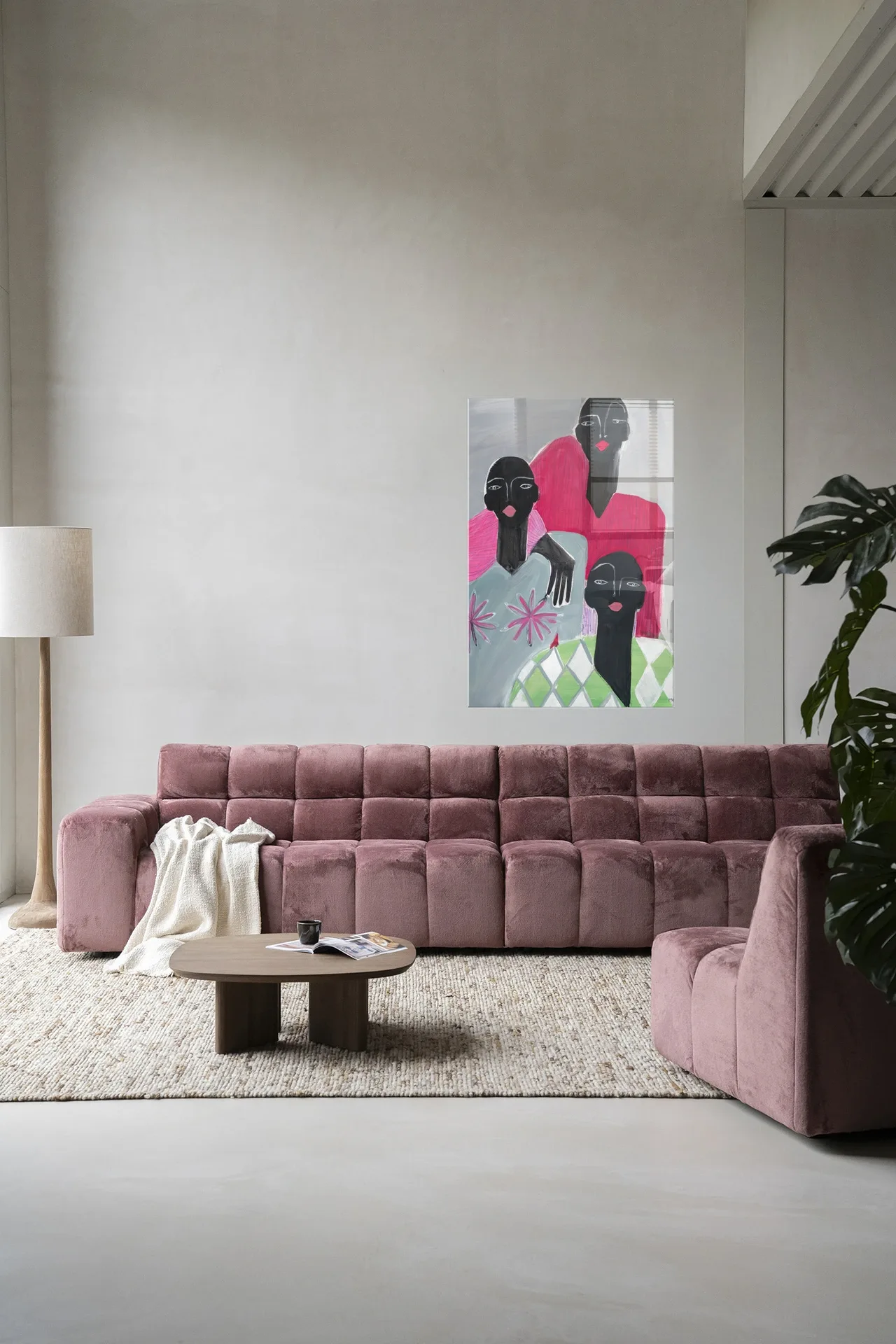 Wandkleed We Are Family van Urban Cotton hangt boven een roze bank in een moderne woonkamer