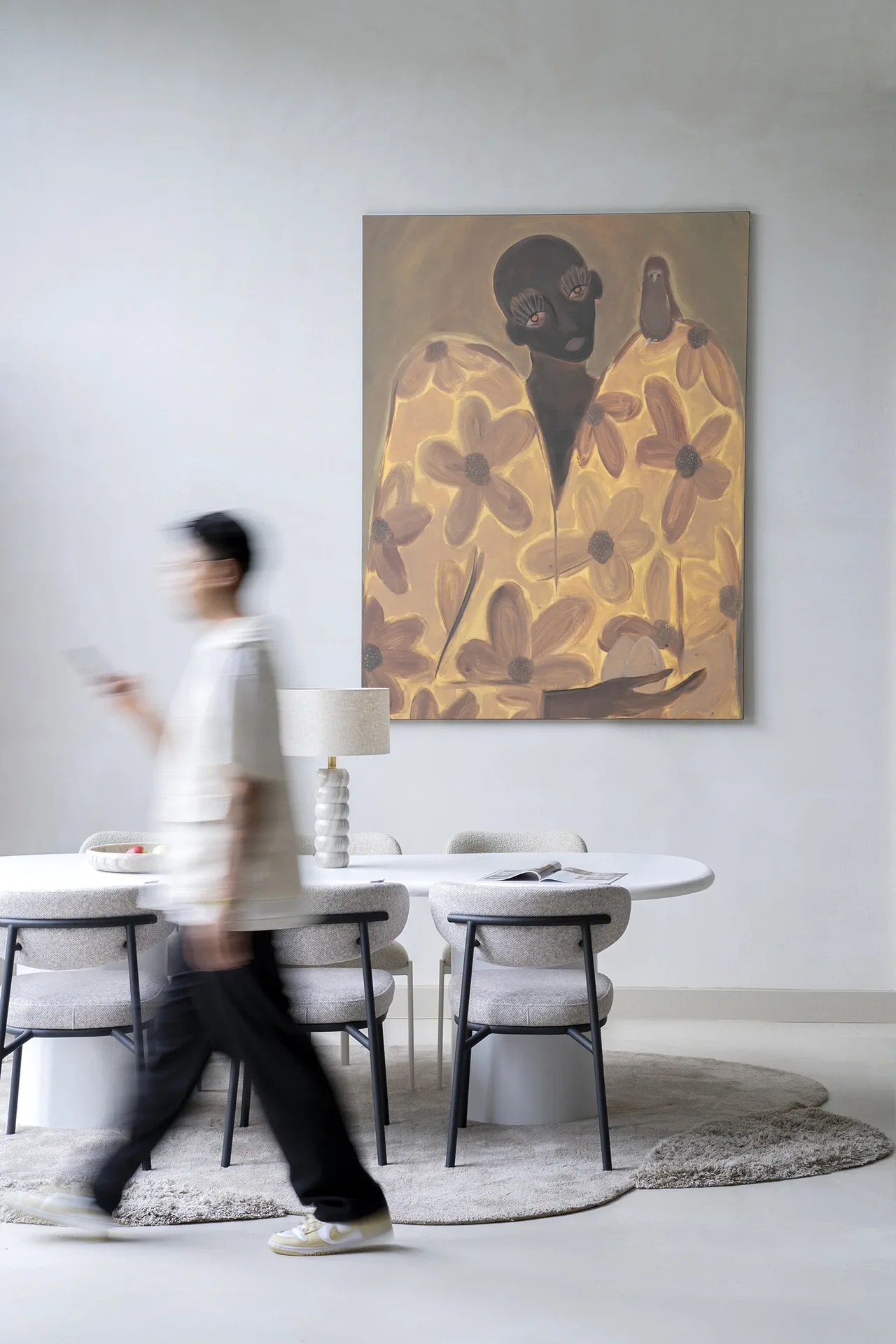 Wandkleed Twins - Urban Cotton hangt aan een witte muur boven een eettafel met stoelen