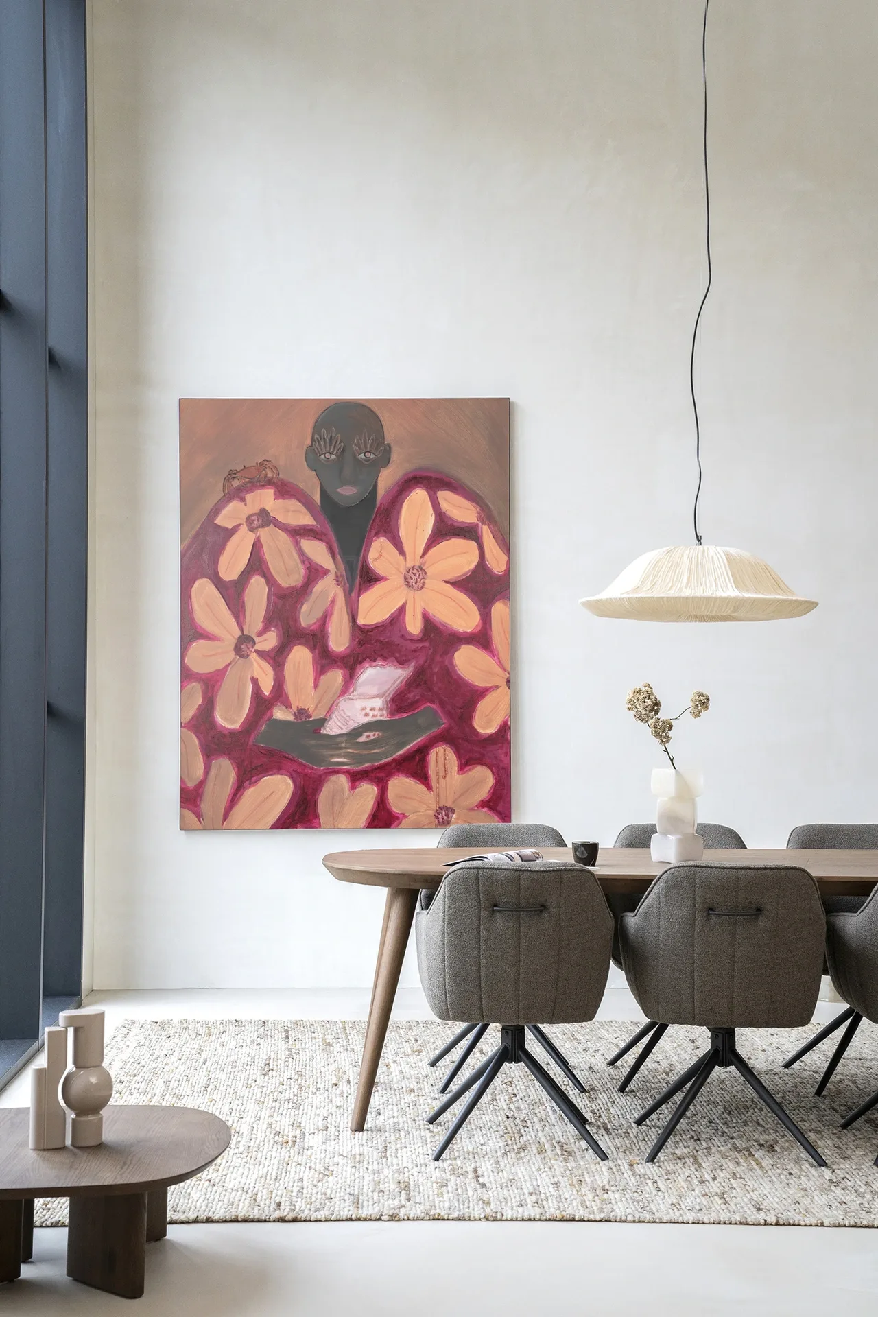 Wandkleed Borrowed Home - Urban Cotton hangend aan een lichte muur boven een eettafel