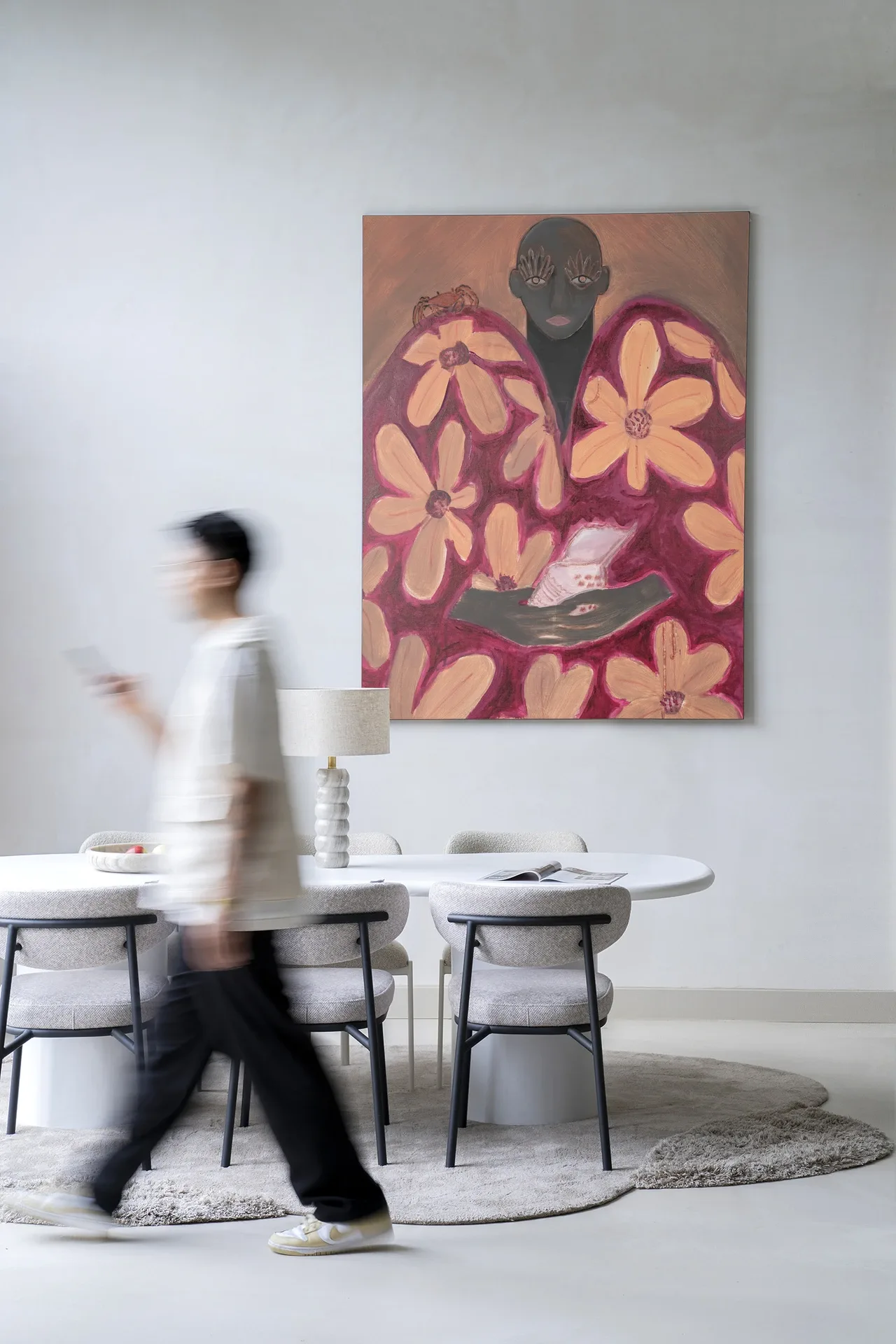 Wandkleed Borrowed Home - Urban Cotton hangt boven een eettafel met stoelen en een lamp