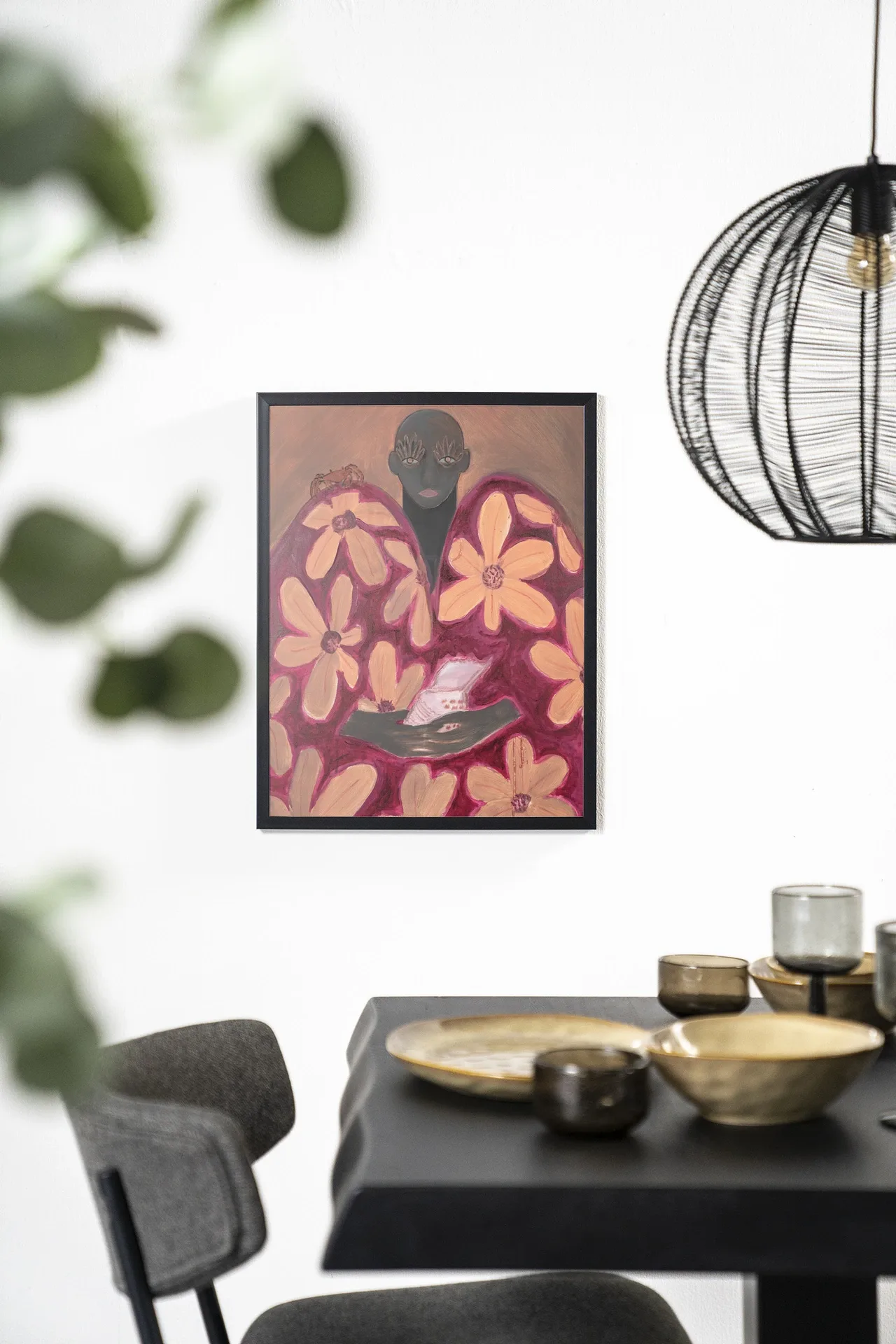 Wandkleed Borrowed Home - Urban Cotton hangend aan een witte muur boven een zwarte tafel