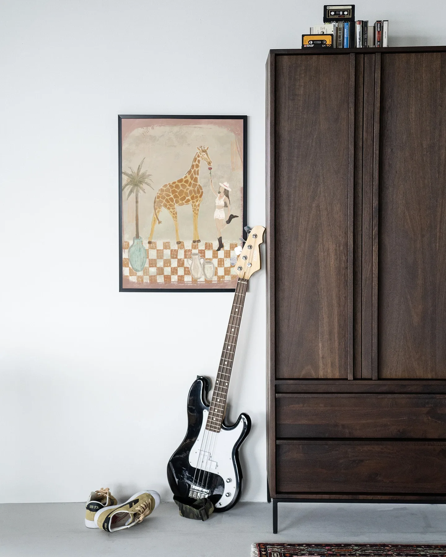 Wandkleed Feeding Rose - Urban Cotton hangt aan een witte muur naast een donkerbruine kast