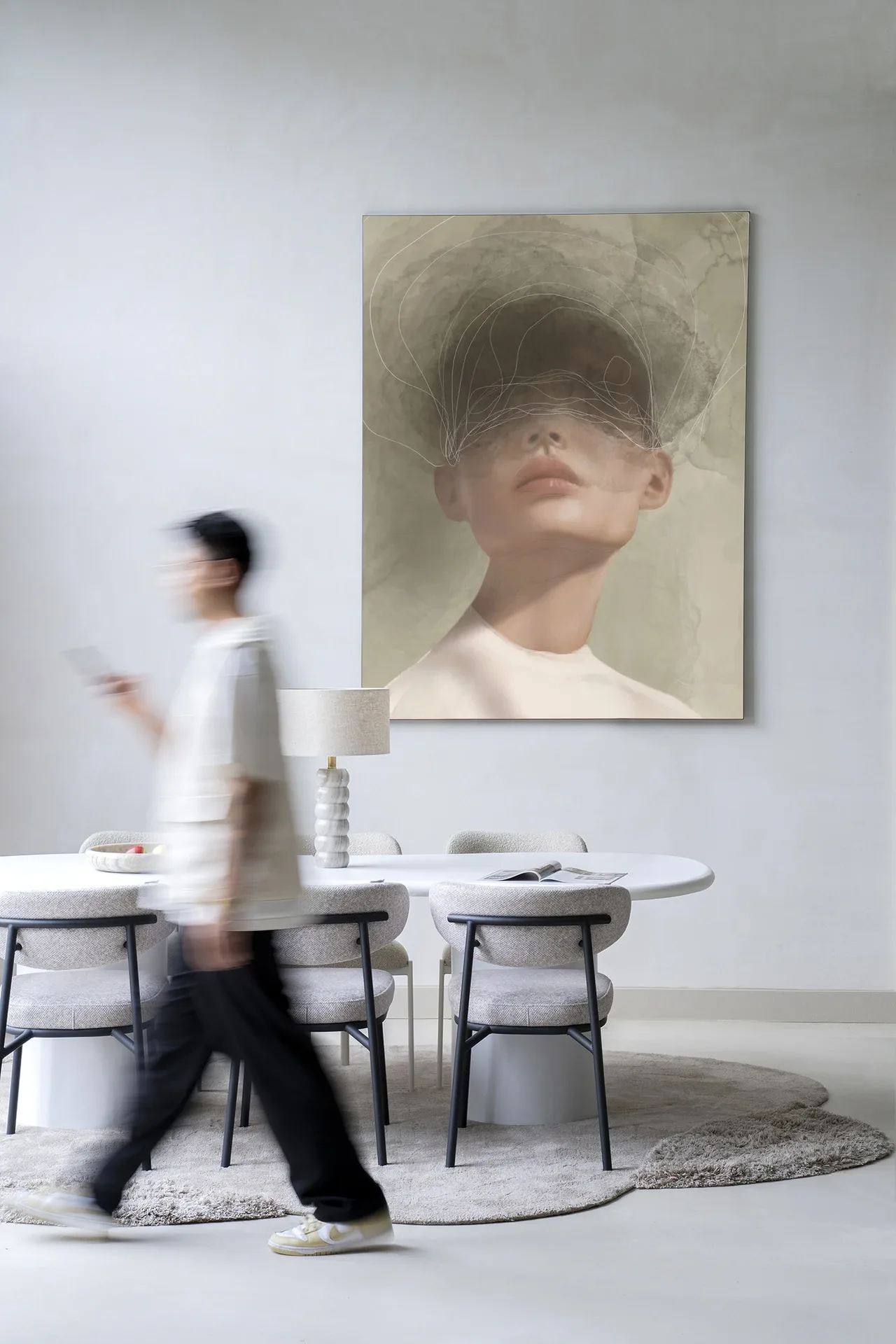 Wandkleed Blind Mist - Urban Cotton hangt aan een witte muur boven een eettafel met stoelen