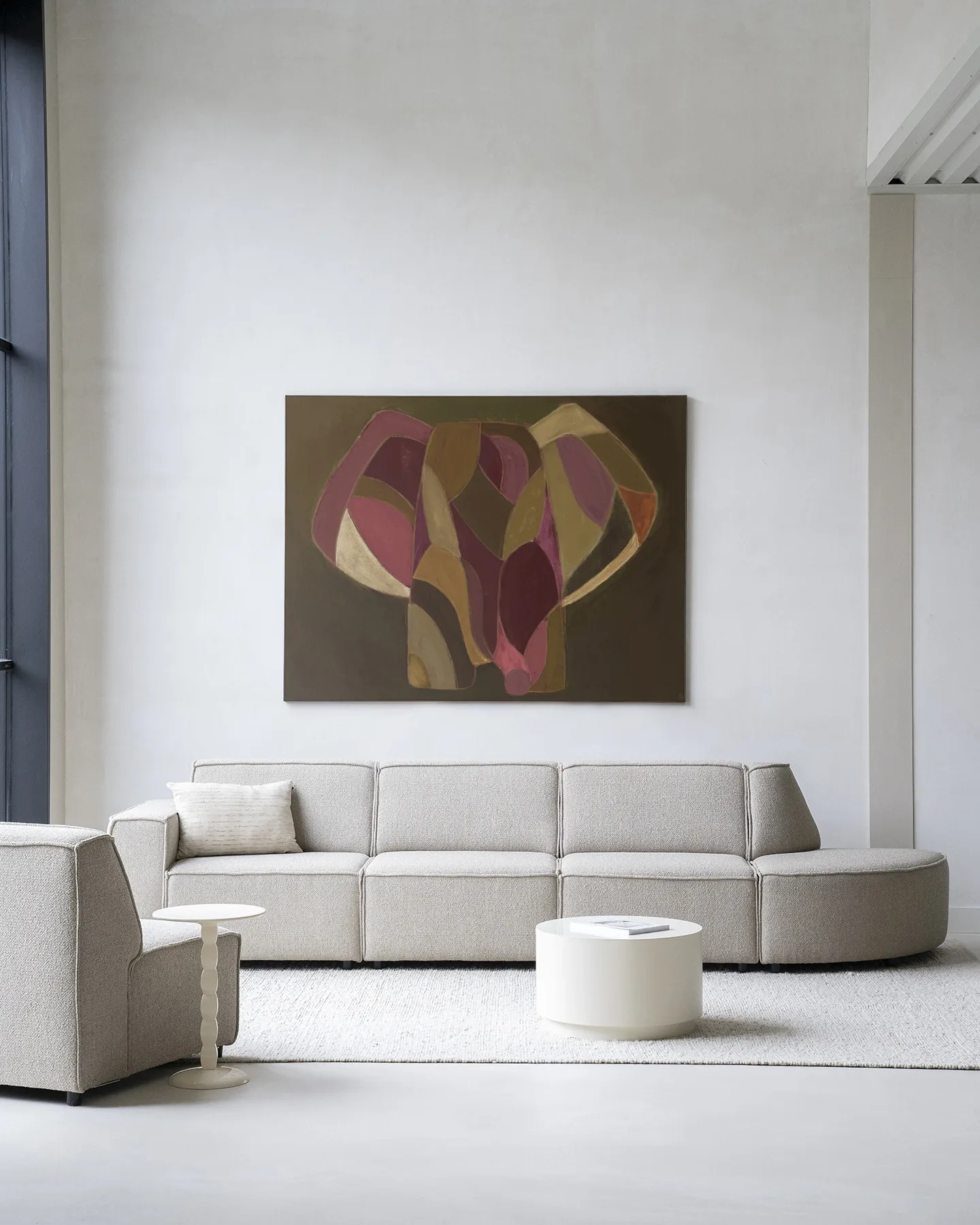 Wandkleed Elefante van Urban Cotton hangt boven een beige bank in een lichte woonkamer