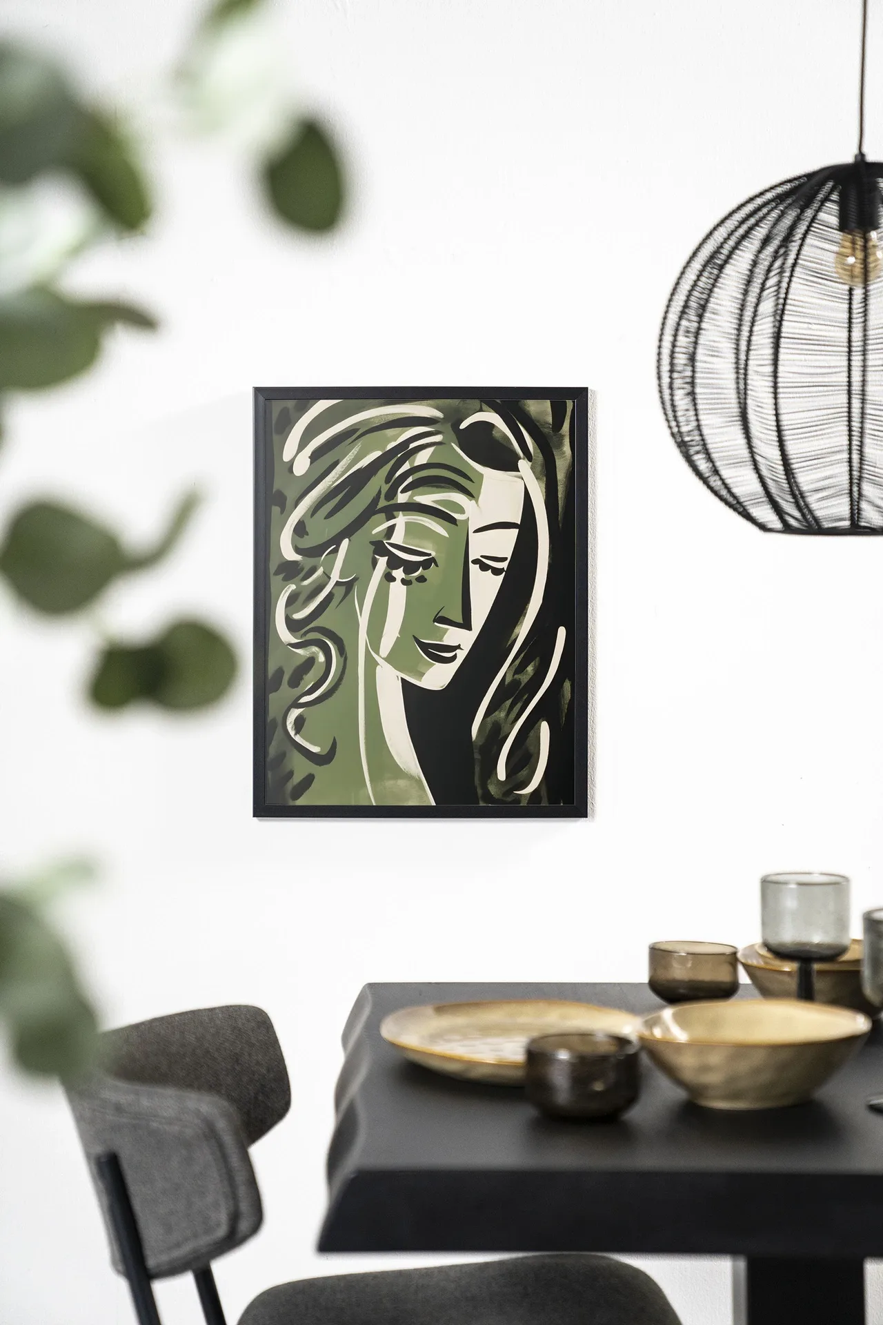 Wandkleed Aphrodite - Urban Cotton hangt aan een witte muur boven een zwarte tafel