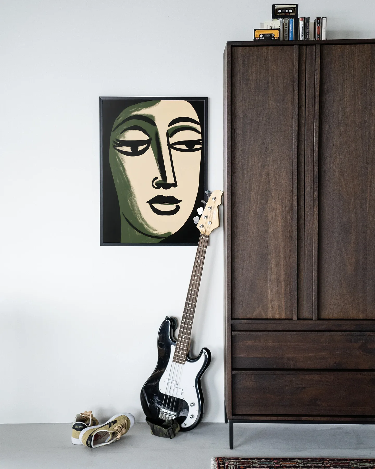 Wandkleed Artemis - Urban Cotton hangend aan een witte muur naast een houten kast met een basgitaar ervoor