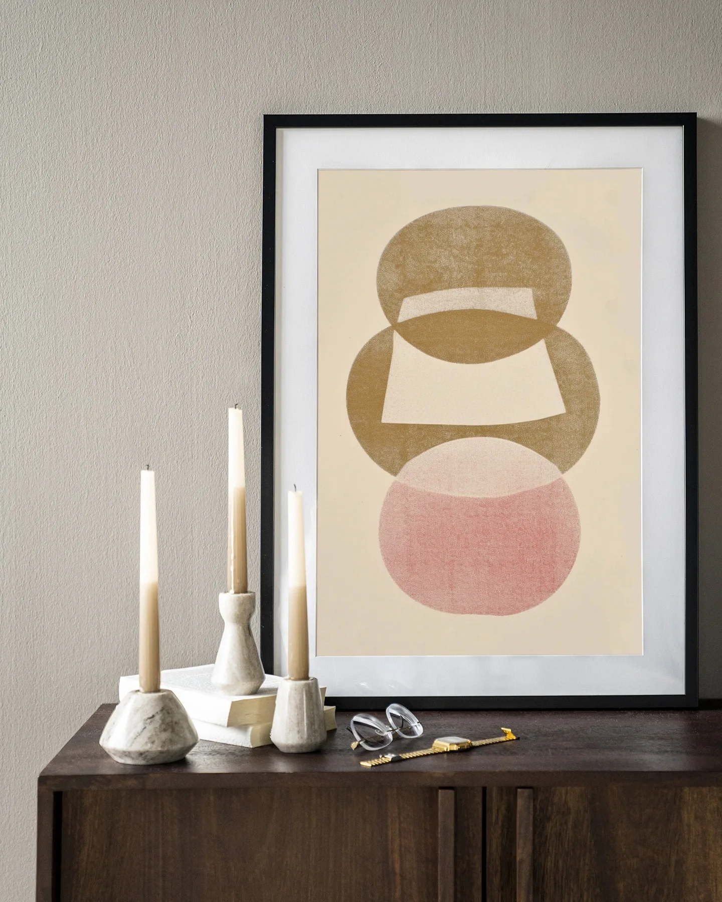 Art print Figuras 1 - Urban Cotton in een zwarte lijst, staand op een donkerbruin dressoir met kaarsen en een bril