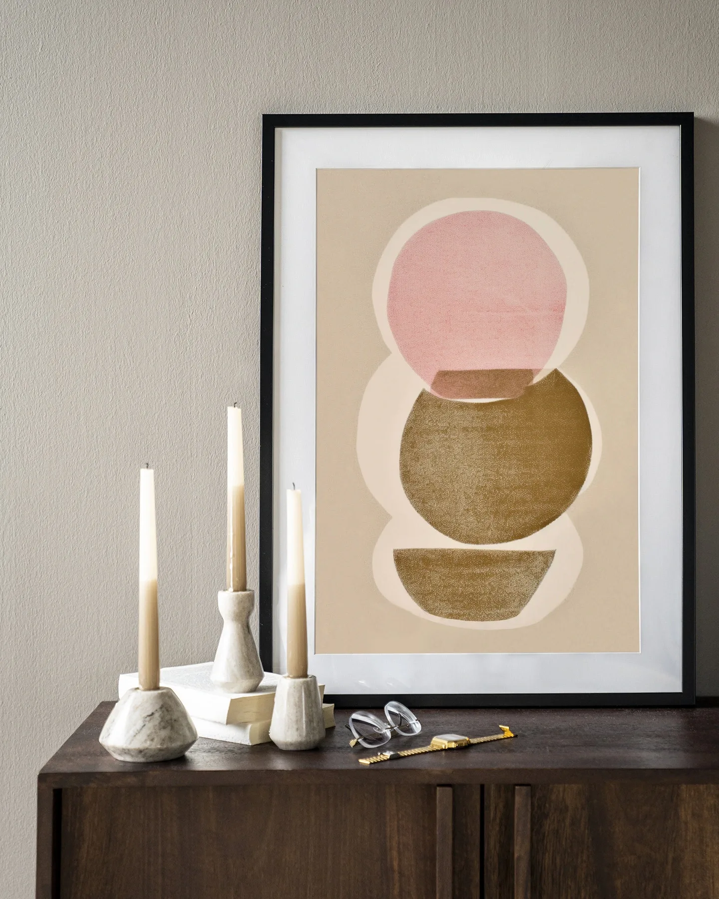 Art print Figuras 5 - Urban Cotton in een zwarte lijst, staand op een donkerbruin dressoir met kaarsen en een bril
