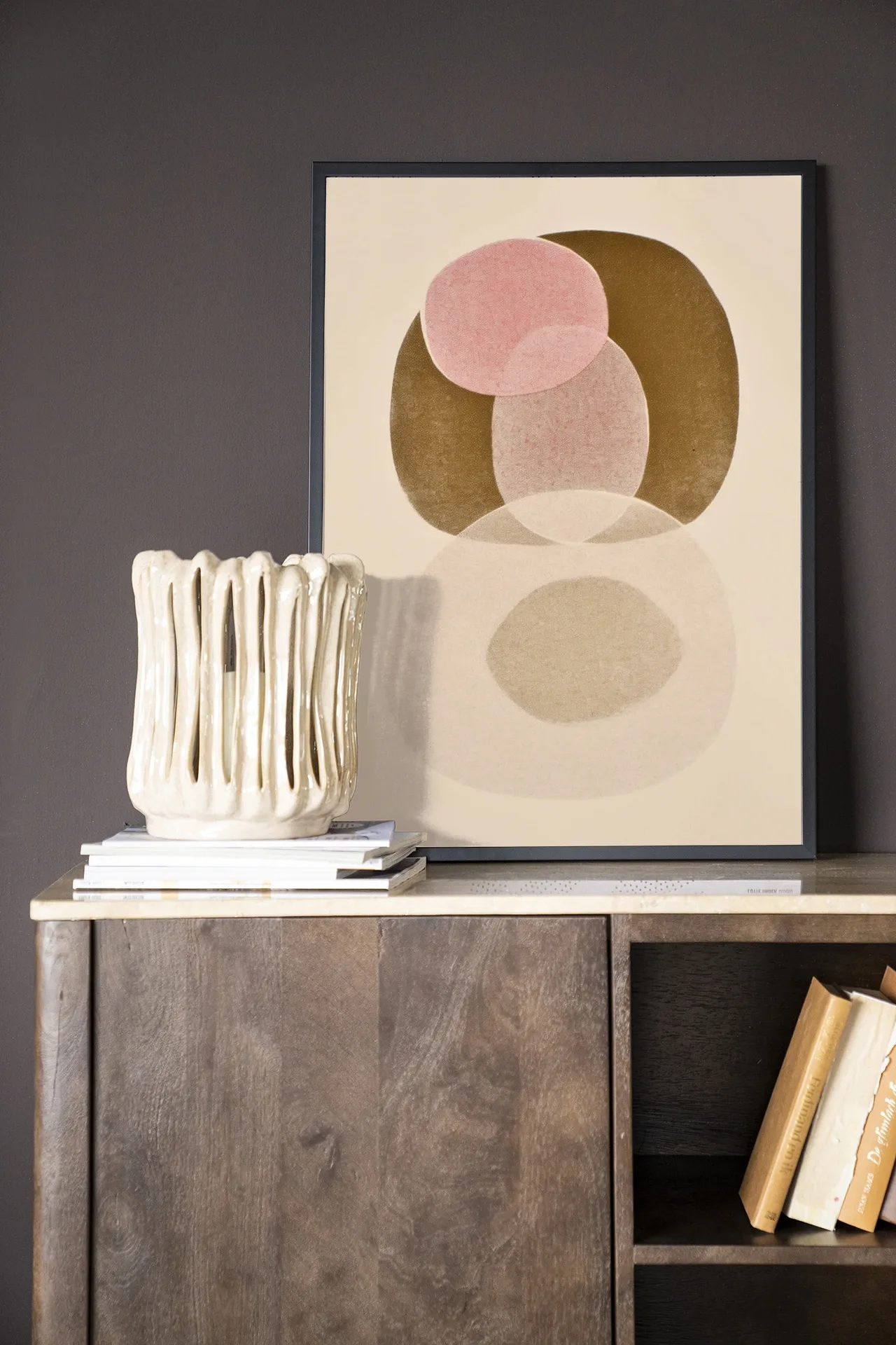 Art print Figuras 7 - Urban Cotton ingelijst en staand op een houten dressoir met een vaas en boeken