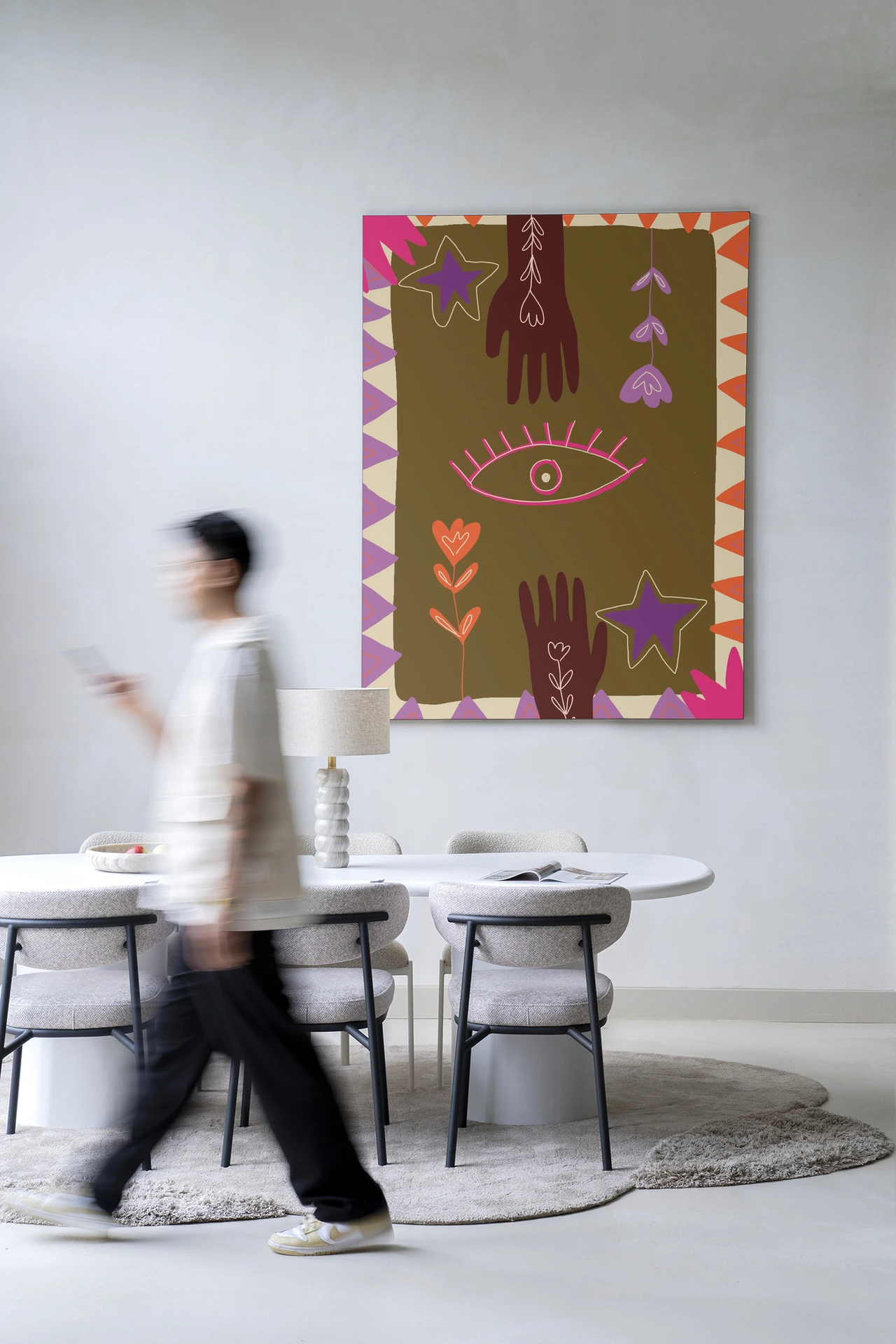 Wandkleed Hands van Urban Cotton hangend aan een lichte muur boven een eettafel met stoelen