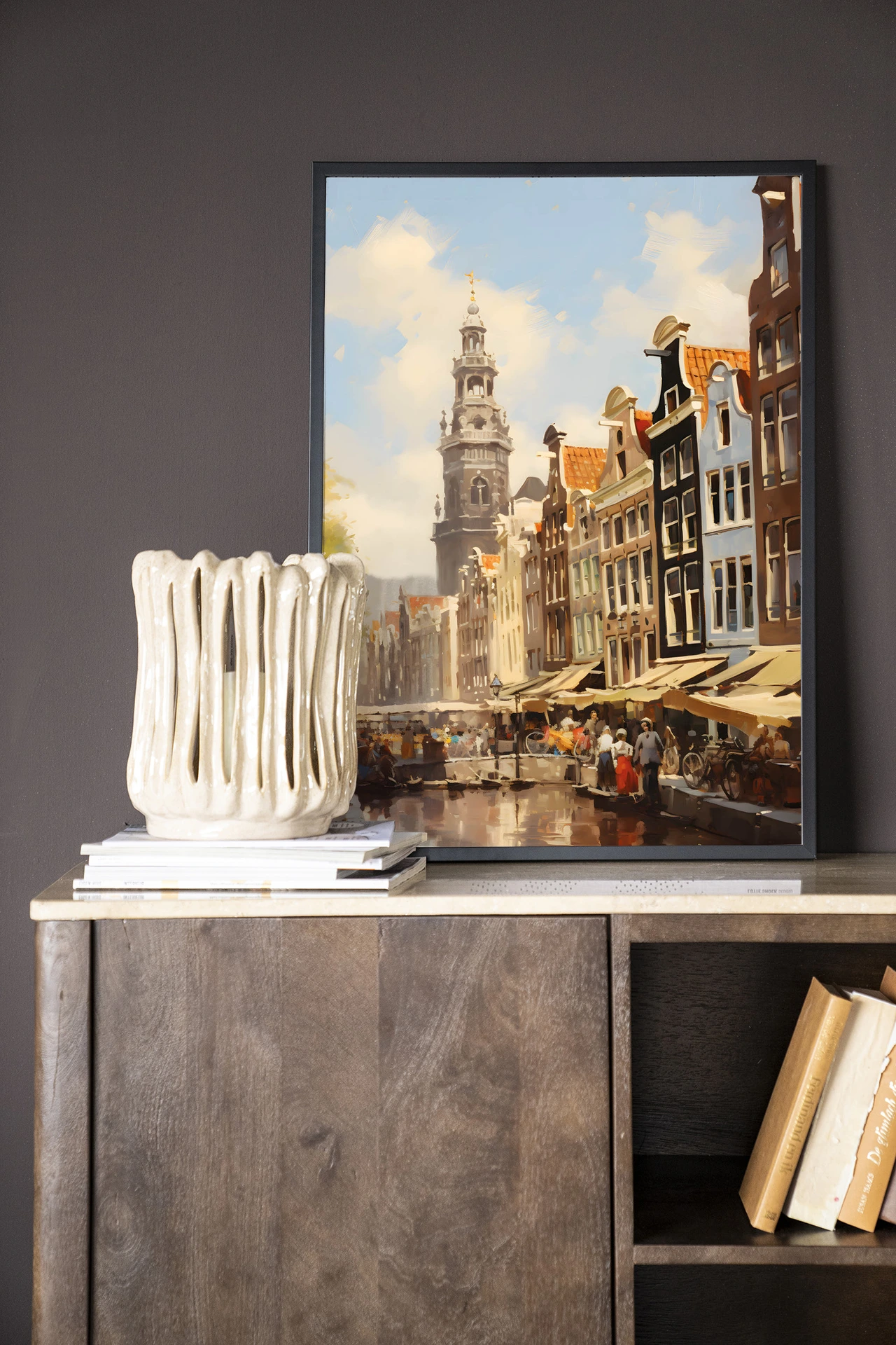 Een Wandkleed Amsterdam - Urban Cotton hangt aan een donkere muur boven een houten dressoir met boeken en een vaas