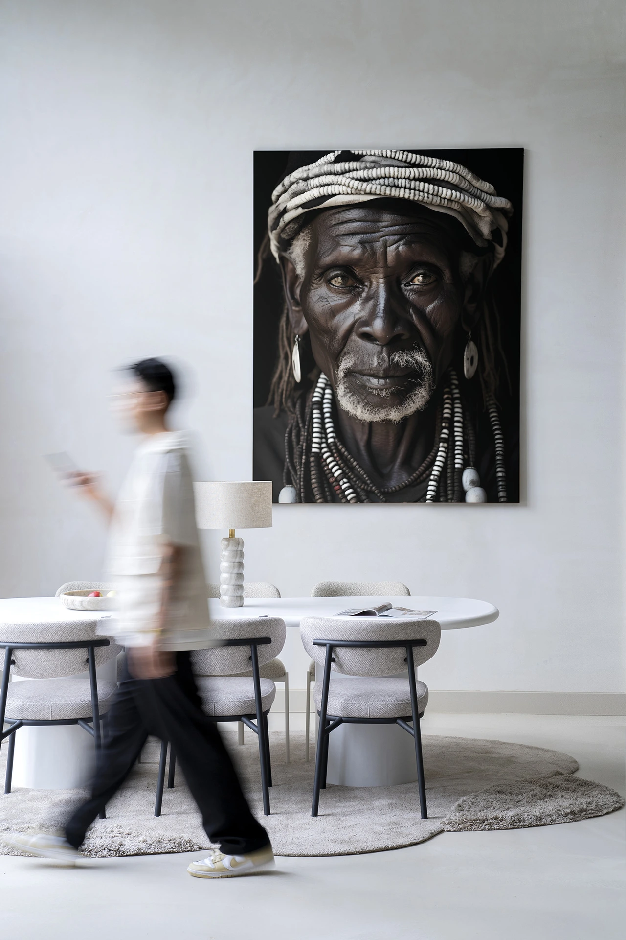 Wandkleed Kabila - Urban Cotton hangt in een moderne eetkamer met een persoon die voorbijloopt