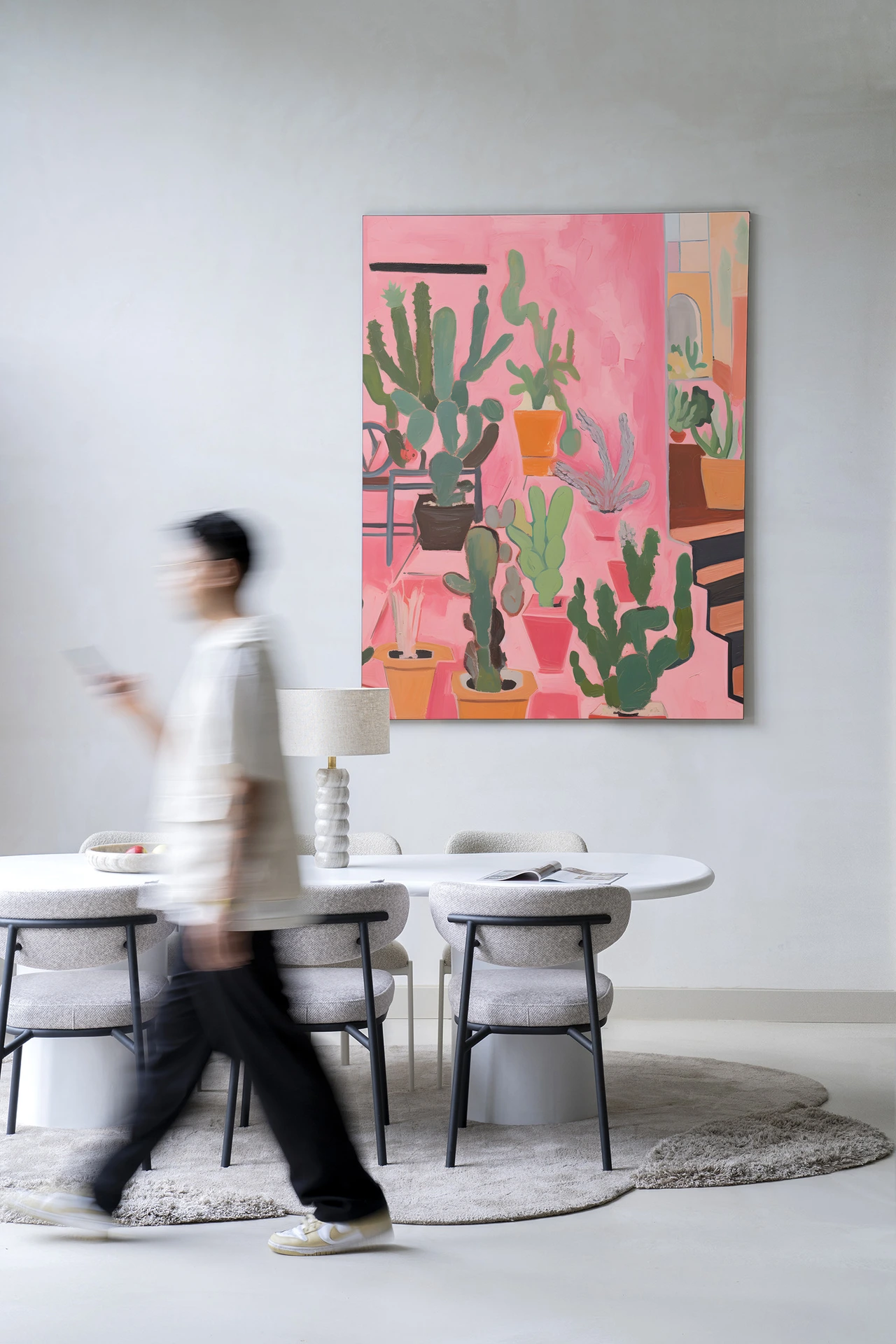 Wandkleed Cactus Party - Urban Cotton aan een lichte muur in een moderne eetkamer met een persoon die voorbijloopt