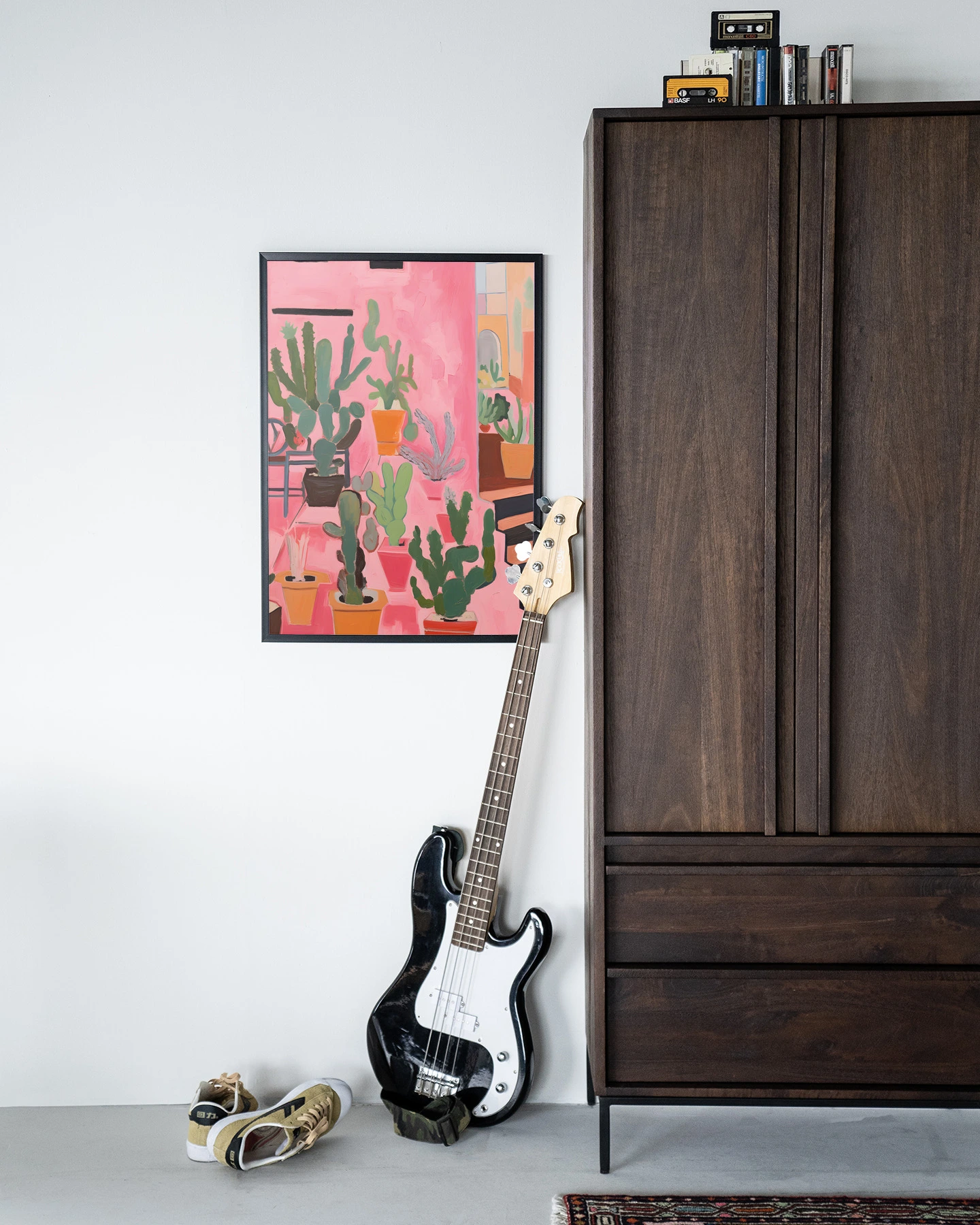 Het Wandkleed Cactus Party - Urban Cotton hangt aan een witte muur naast een donkerbruine kast