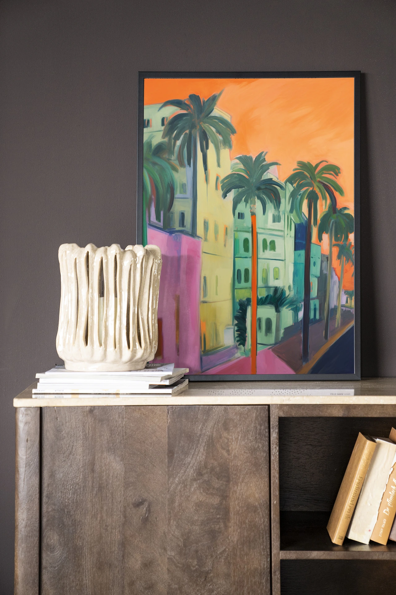 Wandkleed Palm Street - Urban Cotton hangend boven een houten dressoir met decoratie