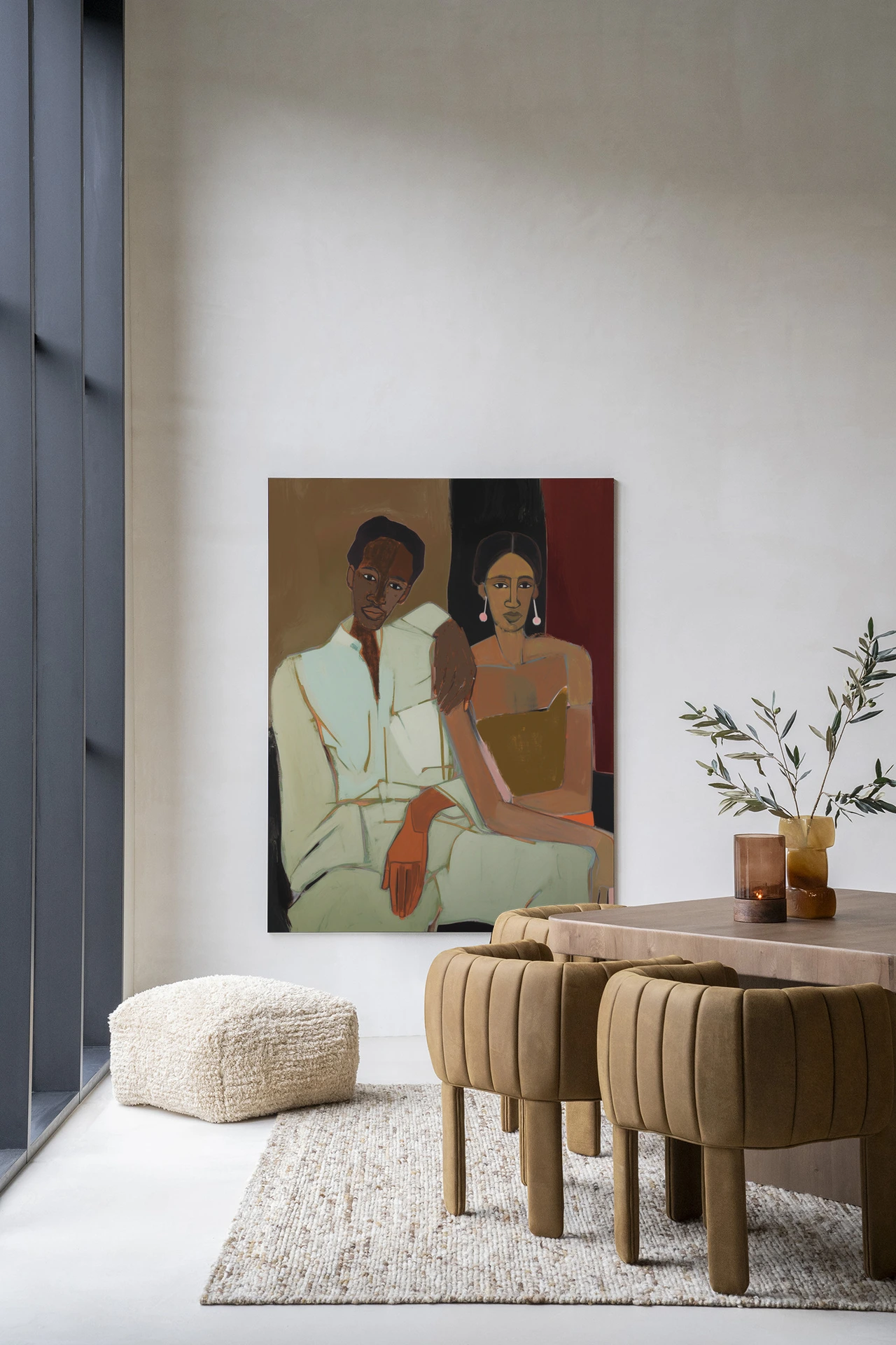 Wandkleed Parental - Urban Cotton hangt aan een witte muur in een modern interieur met een poef en stoelen