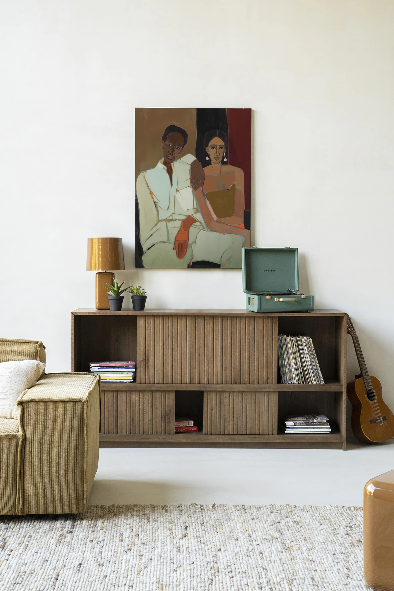 Wandkleed Parental - Urban Cotton hangt boven een houten dressoir met een platenspeler en decoratie in een lichte woonkamer