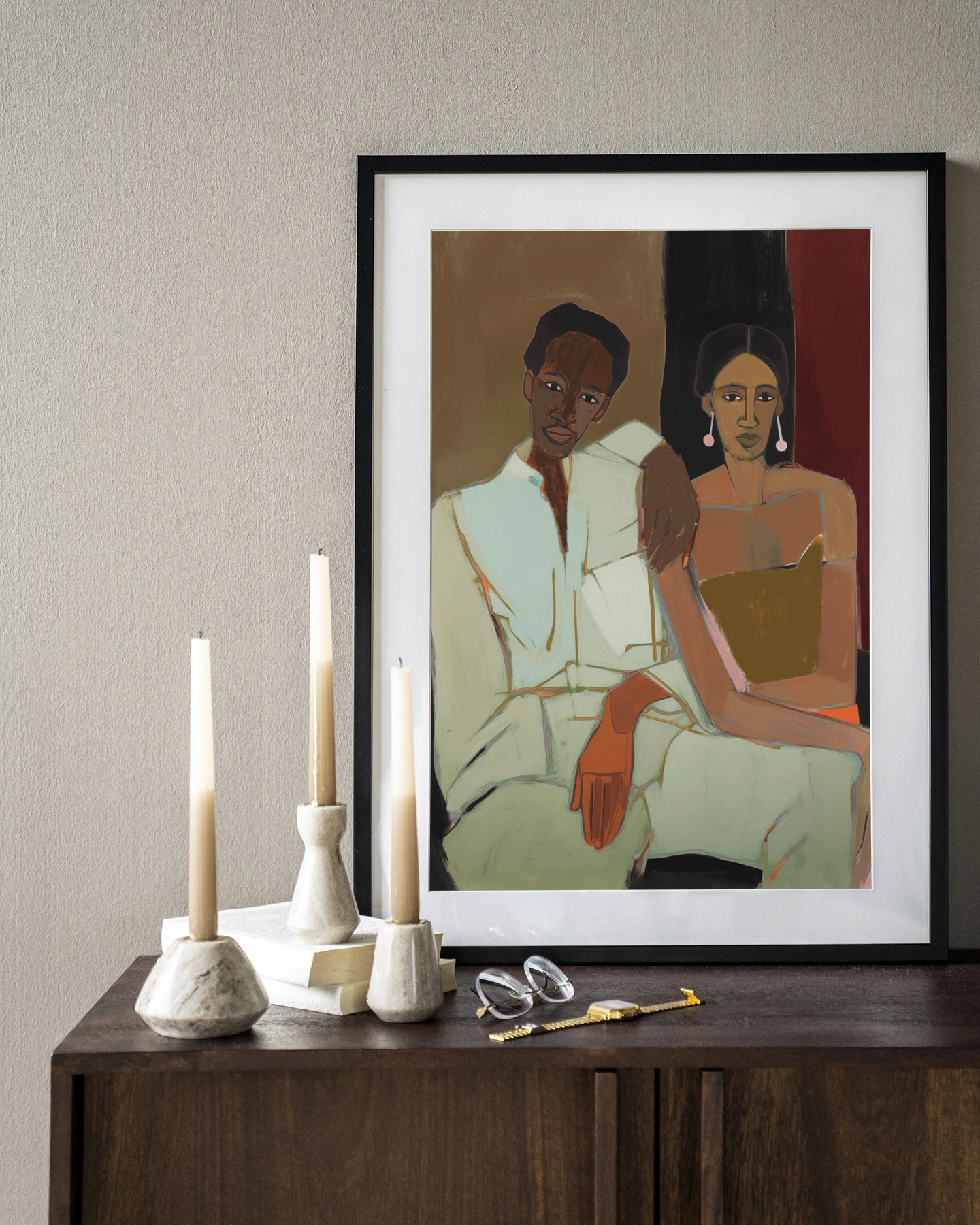 Wandkleed Parental - Urban Cotton hangt boven een houten dressoir met kaarsen en boeken