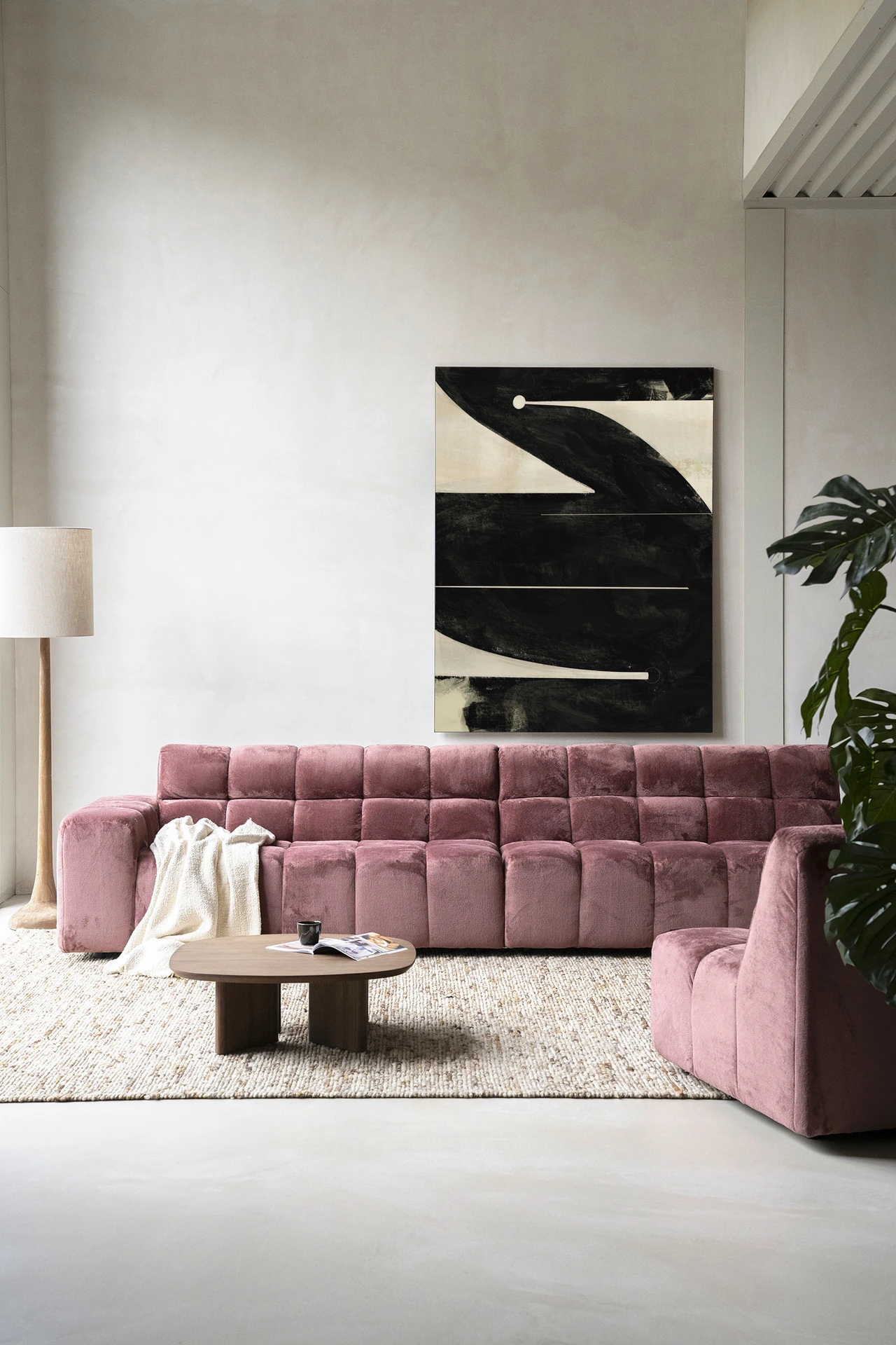 Wandkleed Nocturne Oasis van Urban Cotton hangt boven een roze bank in een moderne woonkamer