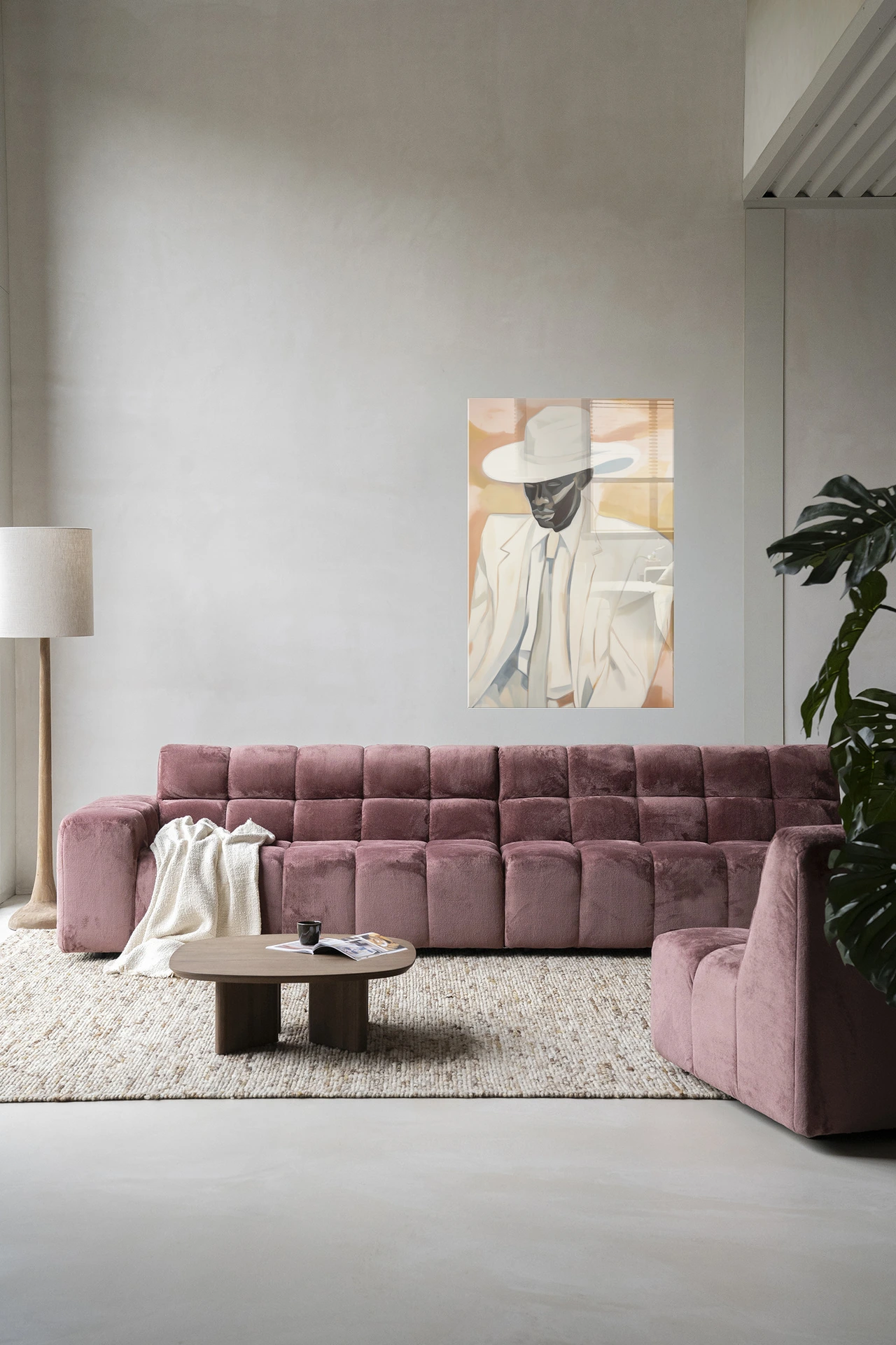 Wandkleed Dusty Don - Urban Cotton hangt boven een roze bank in een moderne woonkamer