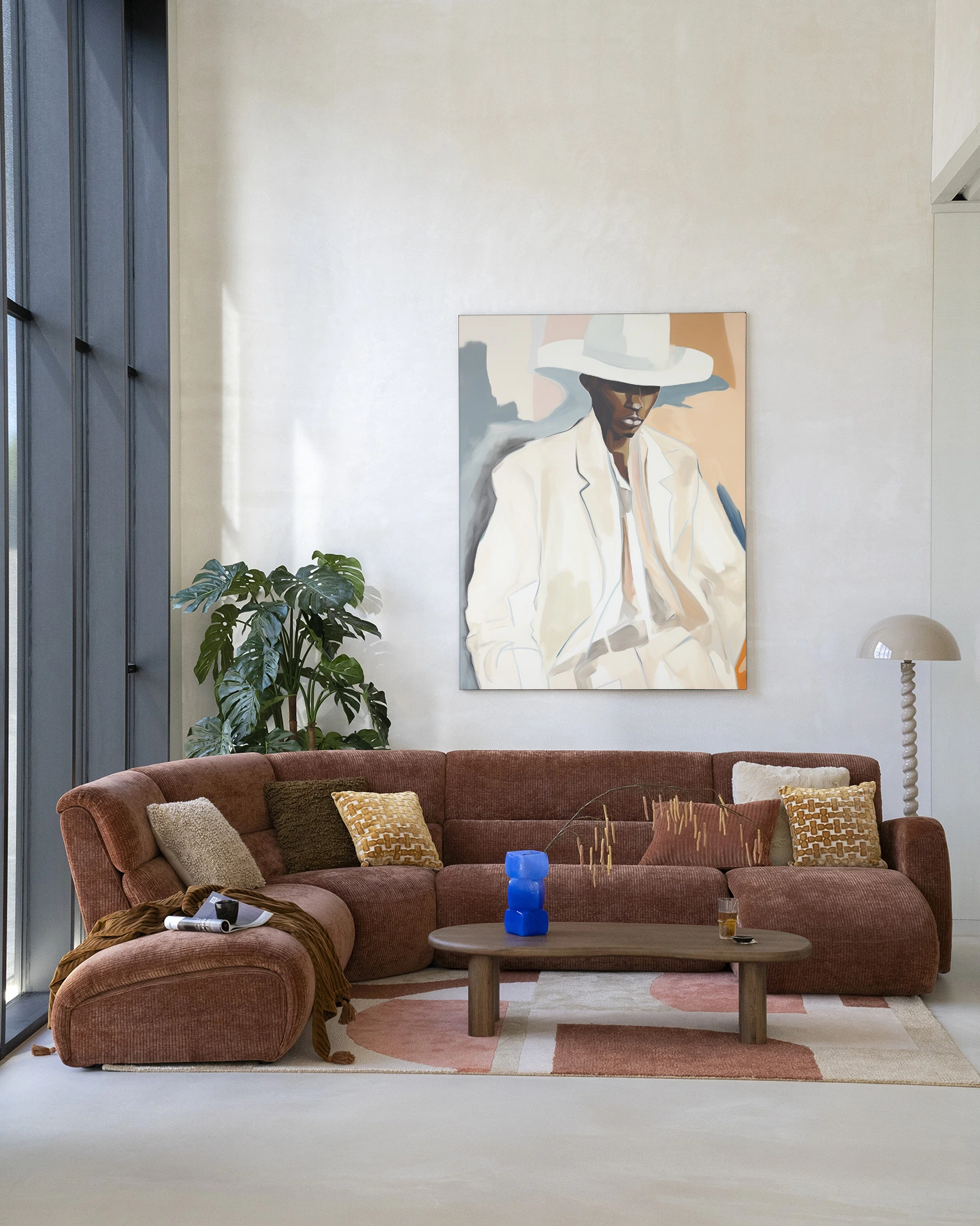 Wandkleed Saloon Sam - Urban Cotton hangend boven een bruine hoekbank in een lichte woonkamer