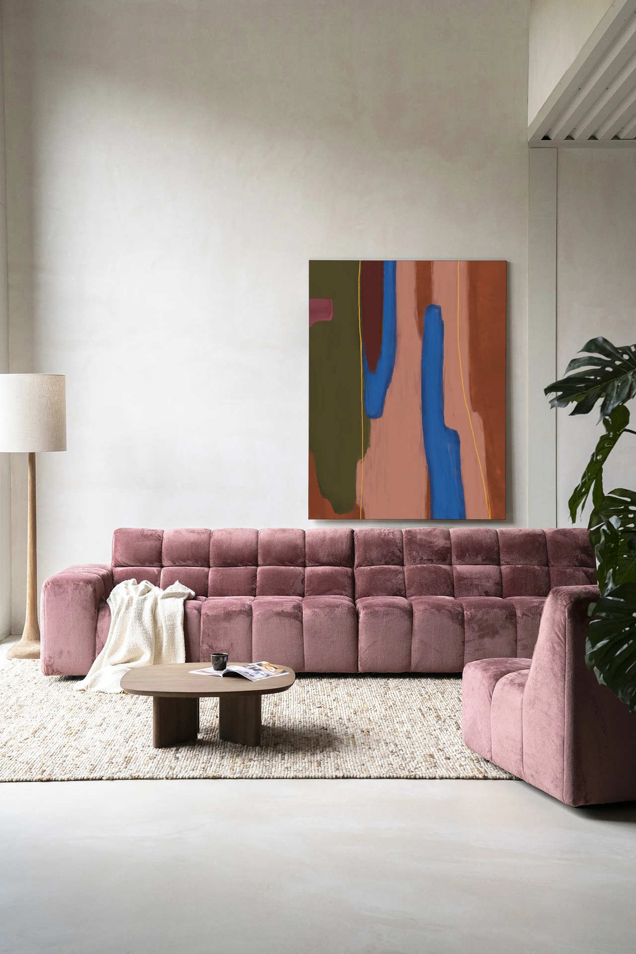 Wandkleed Tajo - Urban Cotton hangt boven een roze bank in een moderne woonkamer