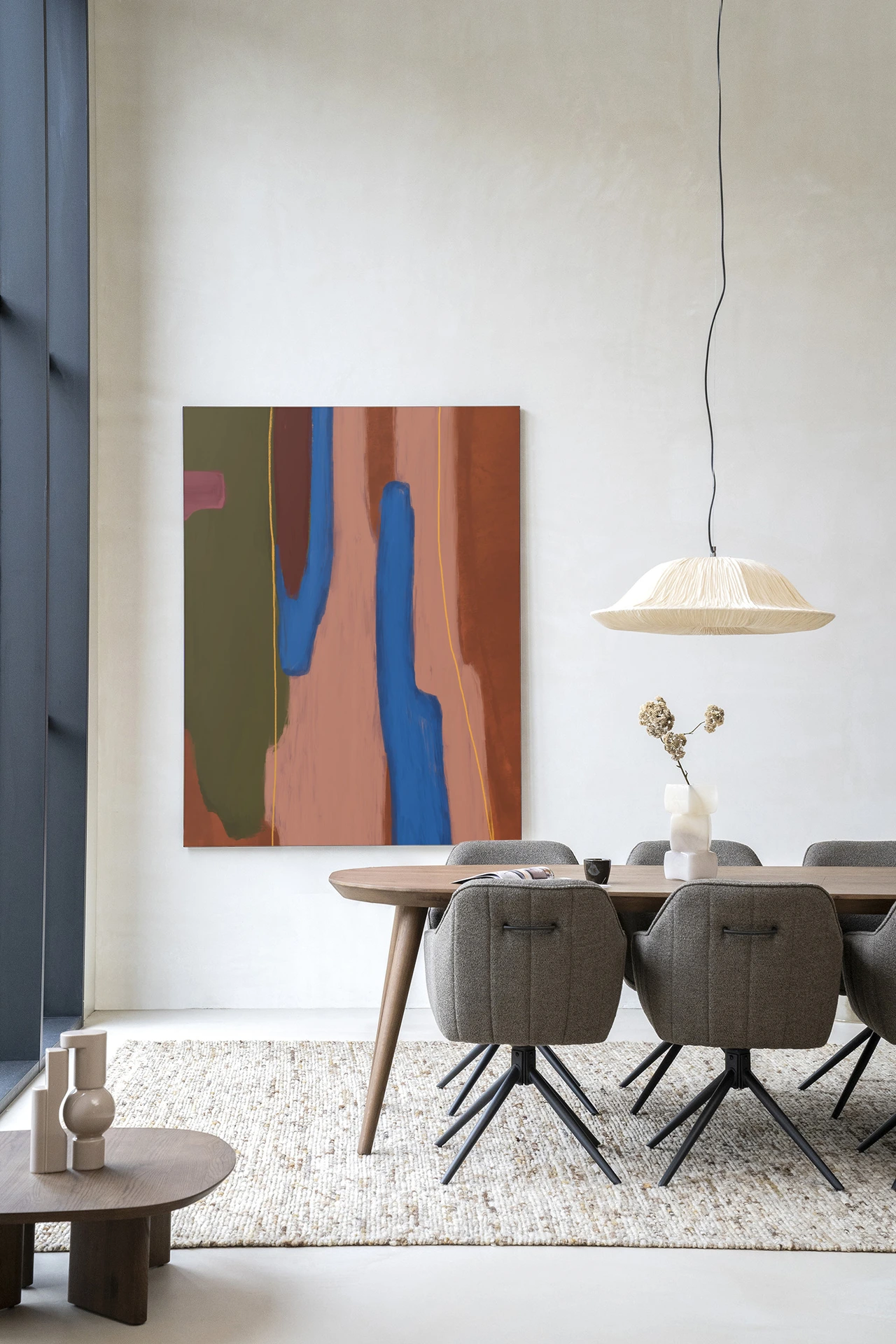 Wandkleed Tajo van Urban Cotton hangt boven een eettafel met zes stoelen in een modern interieur