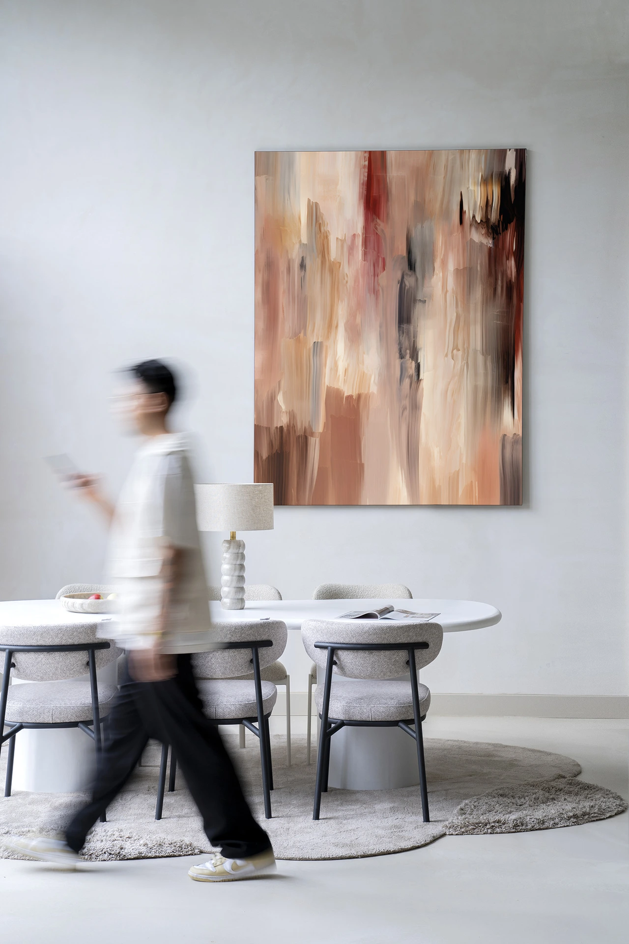 Wandkleed Monterosso - Urban Cotton hangt boven een eettafel met stoelen en een lamp