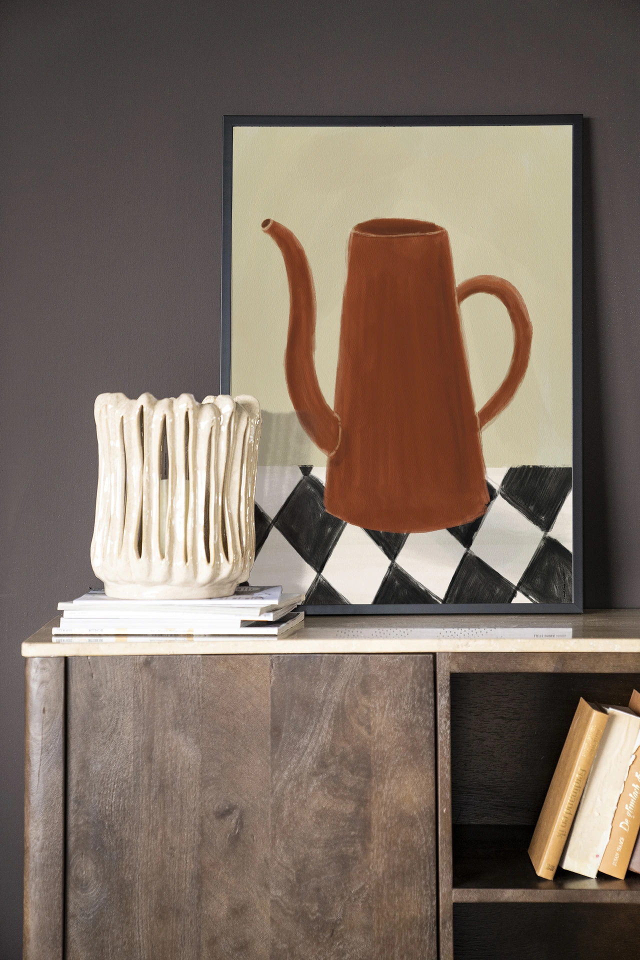 Wandteppich Vivid Vase 02 von Urban Cotton in einem dunkelgrauen Raum, stehend auf einem Holzschrank mit einer Vase und Büchern