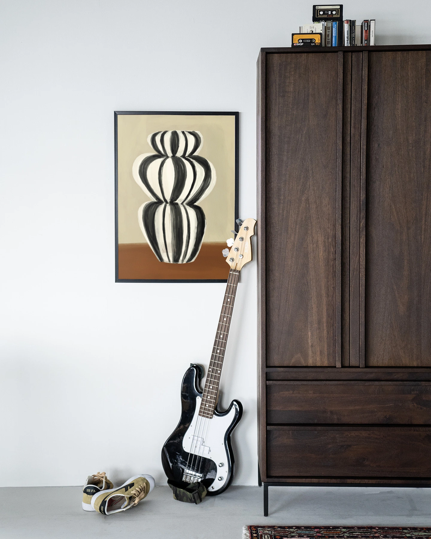 Wandkleed Vivid Vase 03 - Urban Cotton hangend aan een witte muur, met een basgitaar en schoenen ervoor