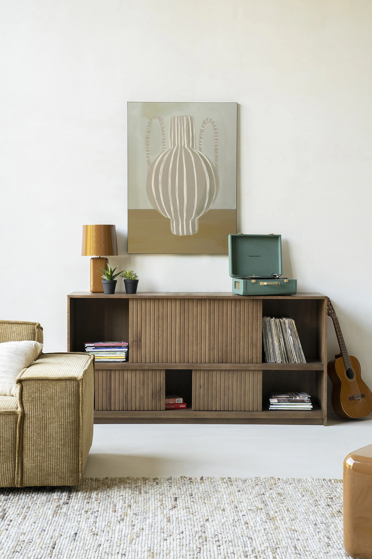Wandkleed Vivid Vase 04 - Urban Cotton hangt boven een dressoir in een lichte woonkamer